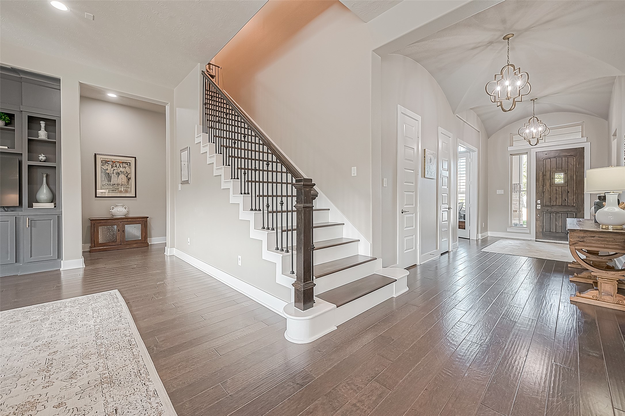 To the right is the front door, stairway to flex room upstairs, and back hall to garage door.