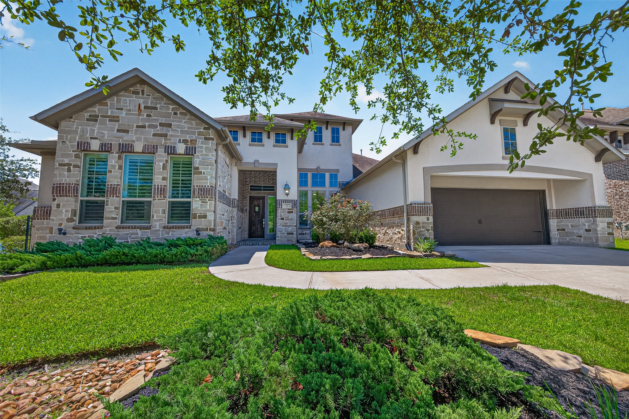 Beautiful stucco and stone exterior creates a welcoming first impression at 30 Argosy Bend, Jaden Oaks in sought after Creekside Park West.