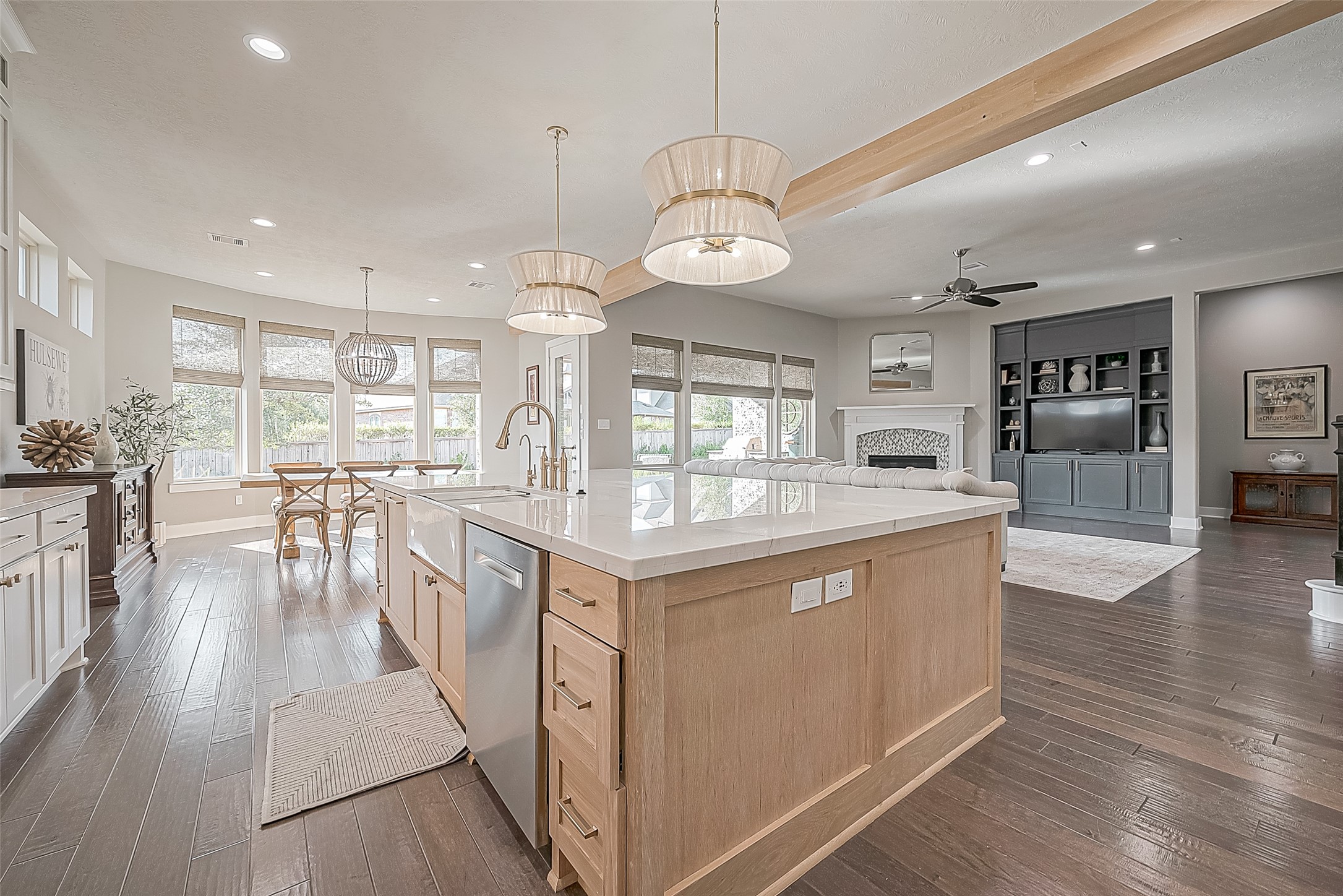 Stunning custom pendants hang elegantly over the quartzite island, adding a touch of sophistication to the space.