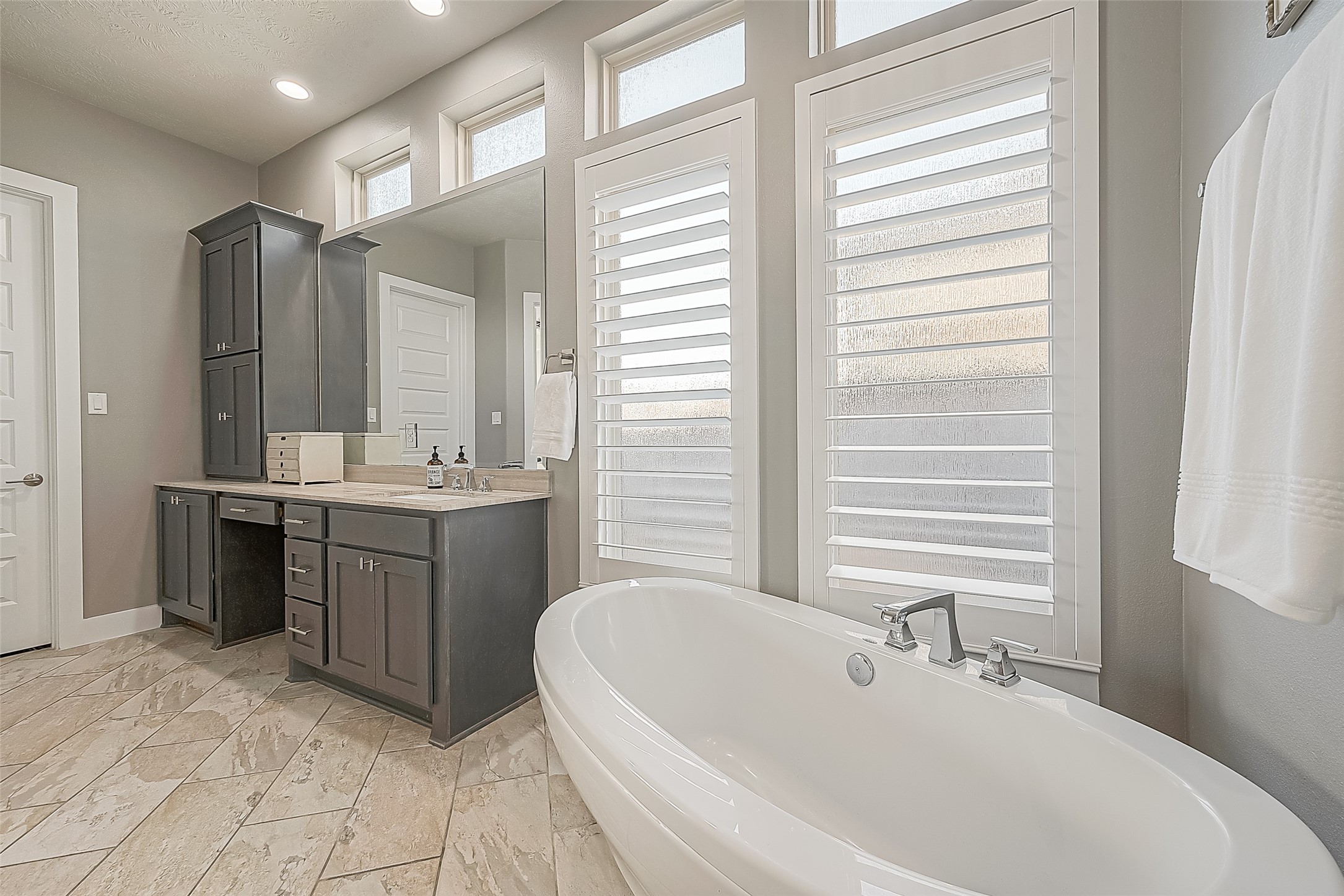 Alternate view of the primary bath and door to one of the walk-in closets.