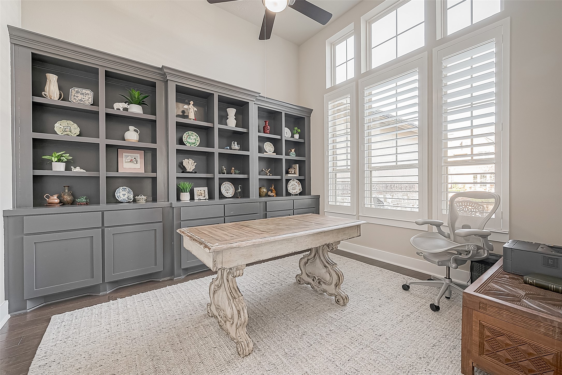 The front-facing study has beautiful custom cabinetry with ample storage, a ceiling fan and Plantation shutters