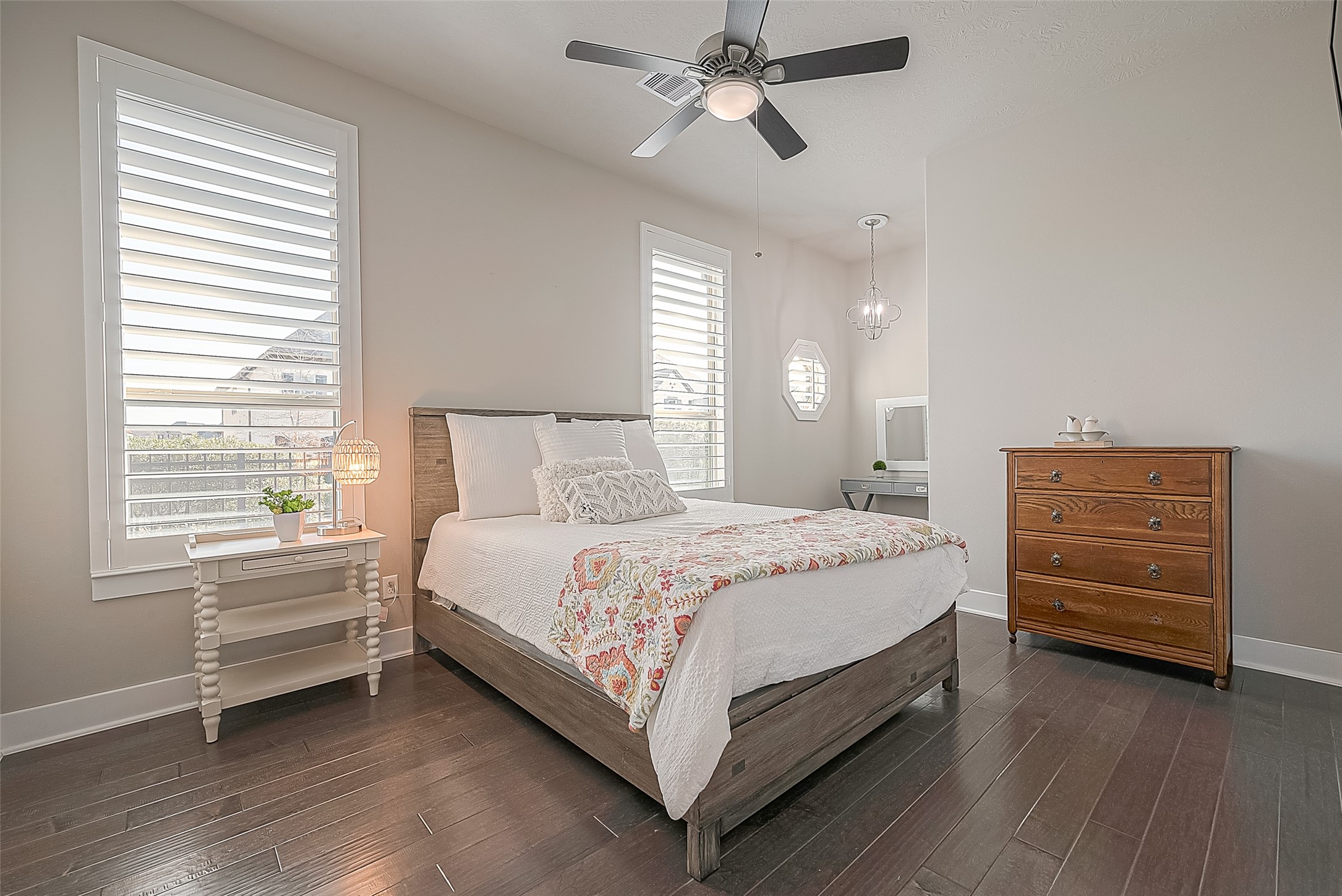 Alternate view of the secondary bedroom side-facing the street.  It has wood flooring, ceiling fan, walk-in closet and a cubby for furniture.