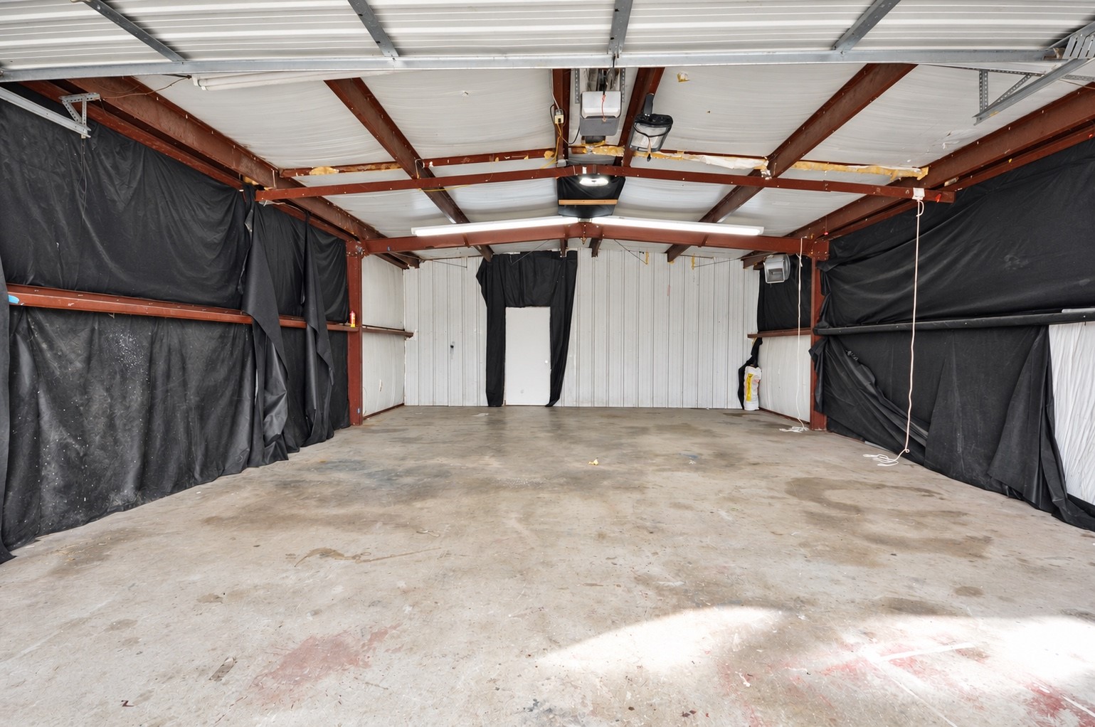 Spacious garage with sturdy metal beams and ample lighting, perfect for storage or workshop use.