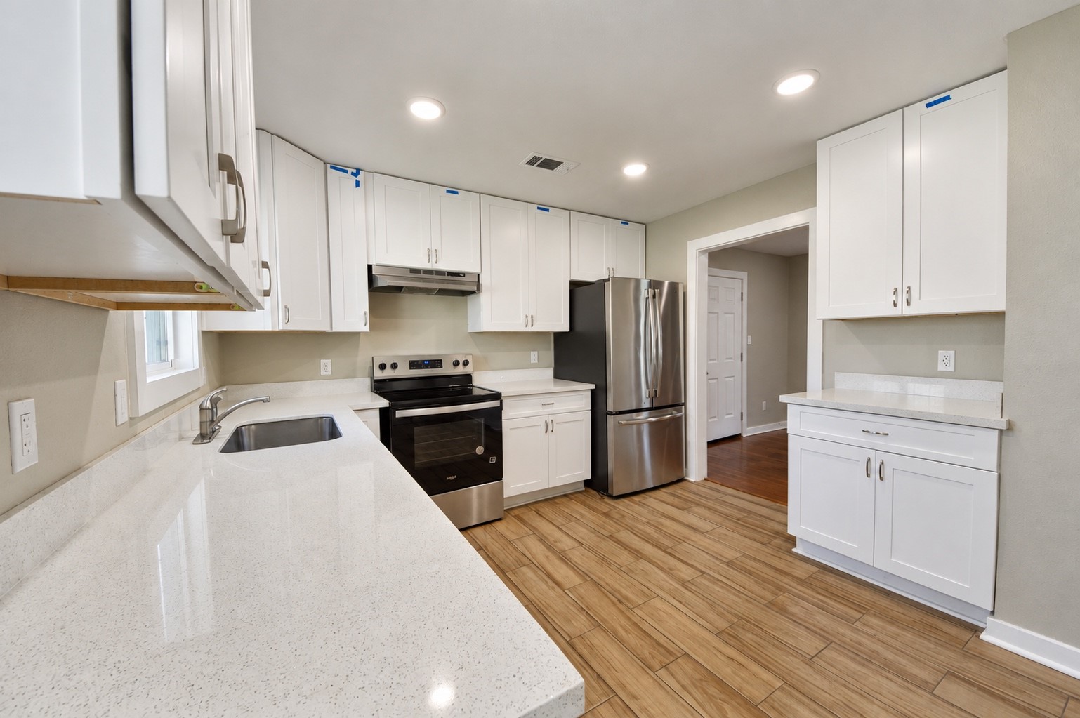 Modern kitchen featuring sleek stainless steel appliances, pristine white cabinetry, and ample counter space with a bright, open layout.