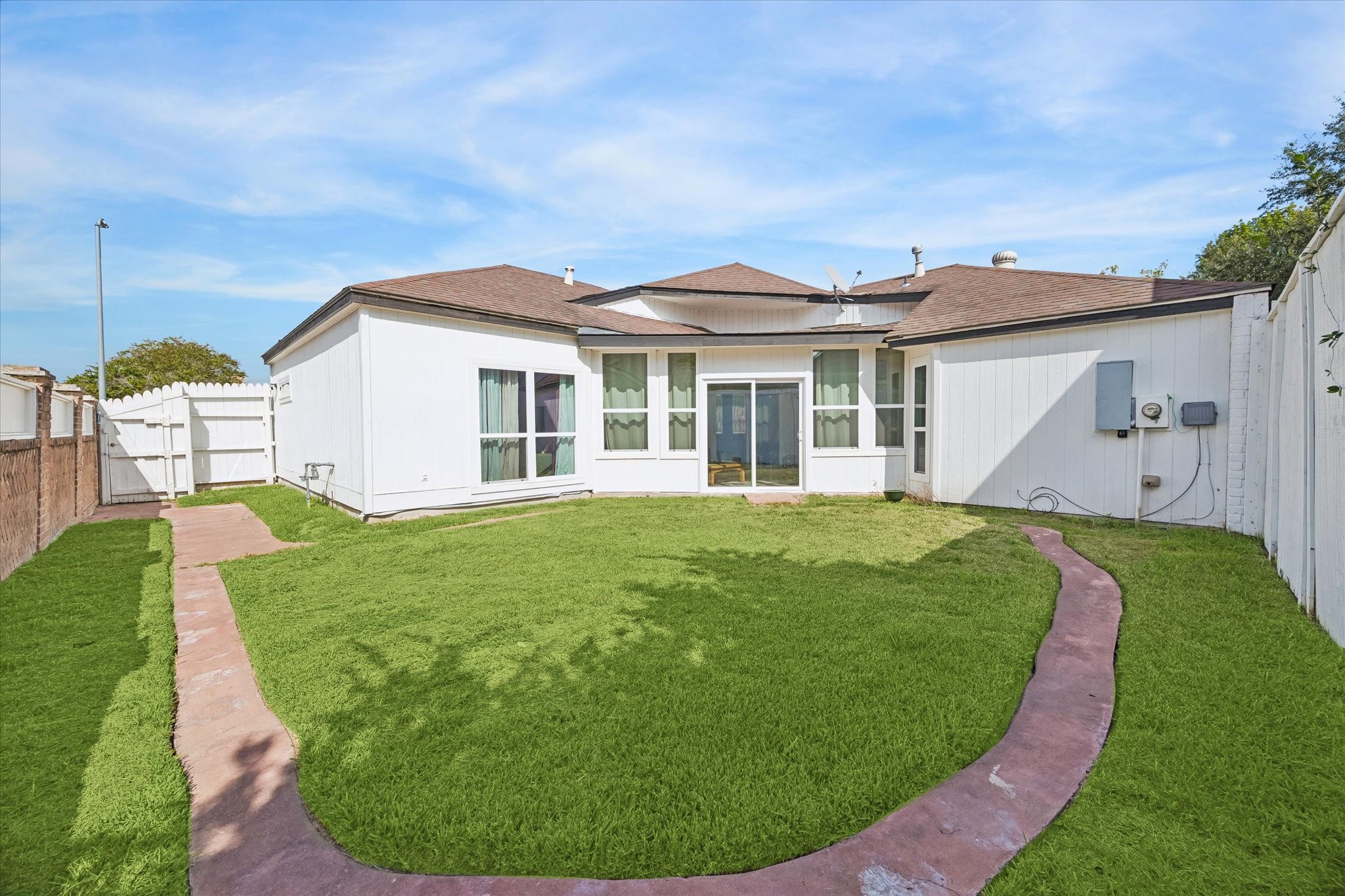 This large backyard with a fence and well-maintained lawn is ready for your own creativity.