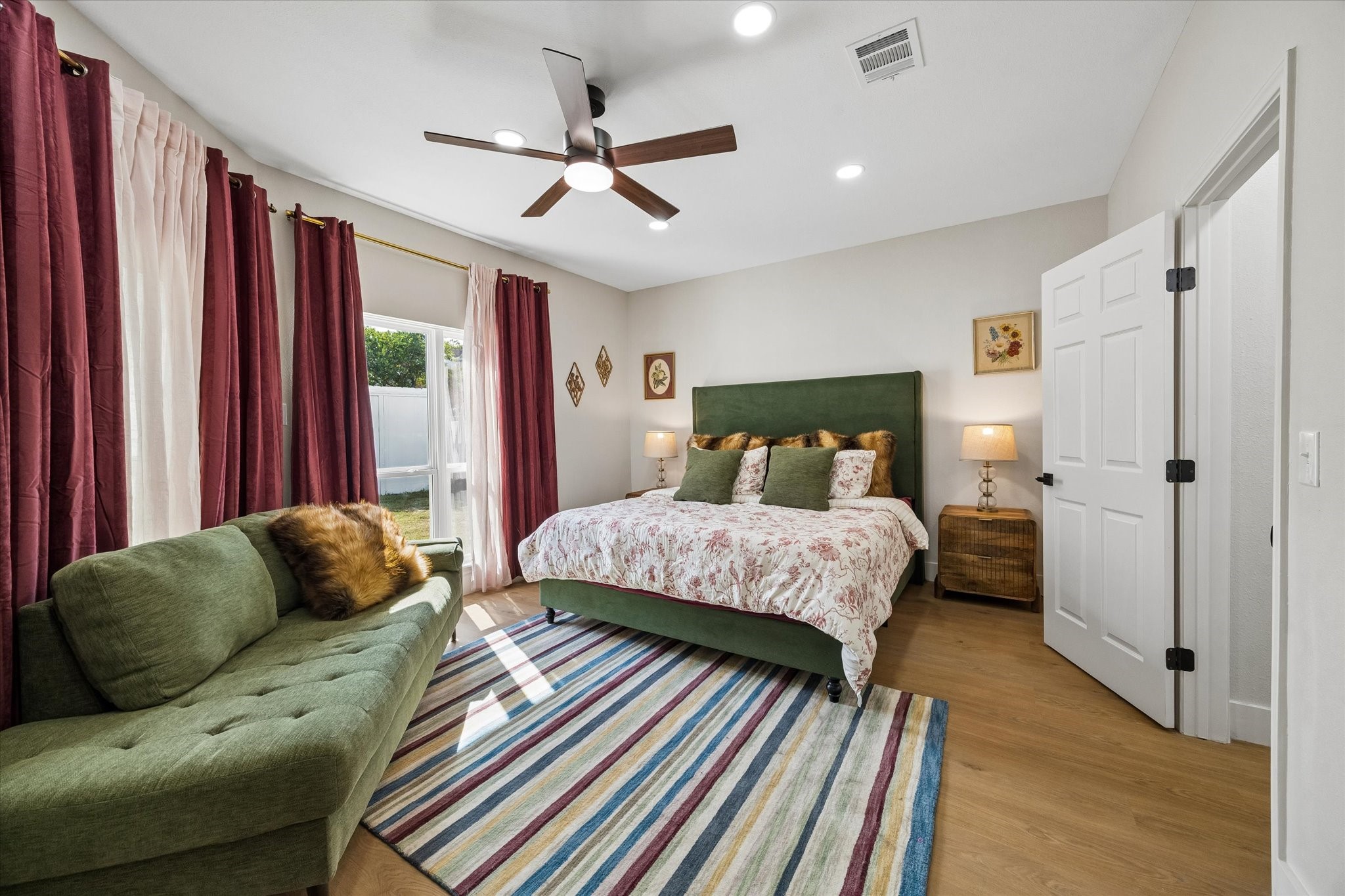 The primary bedroom offers a warm, inviting atmosphere with its large windows and en-suite spa like bathroom area.