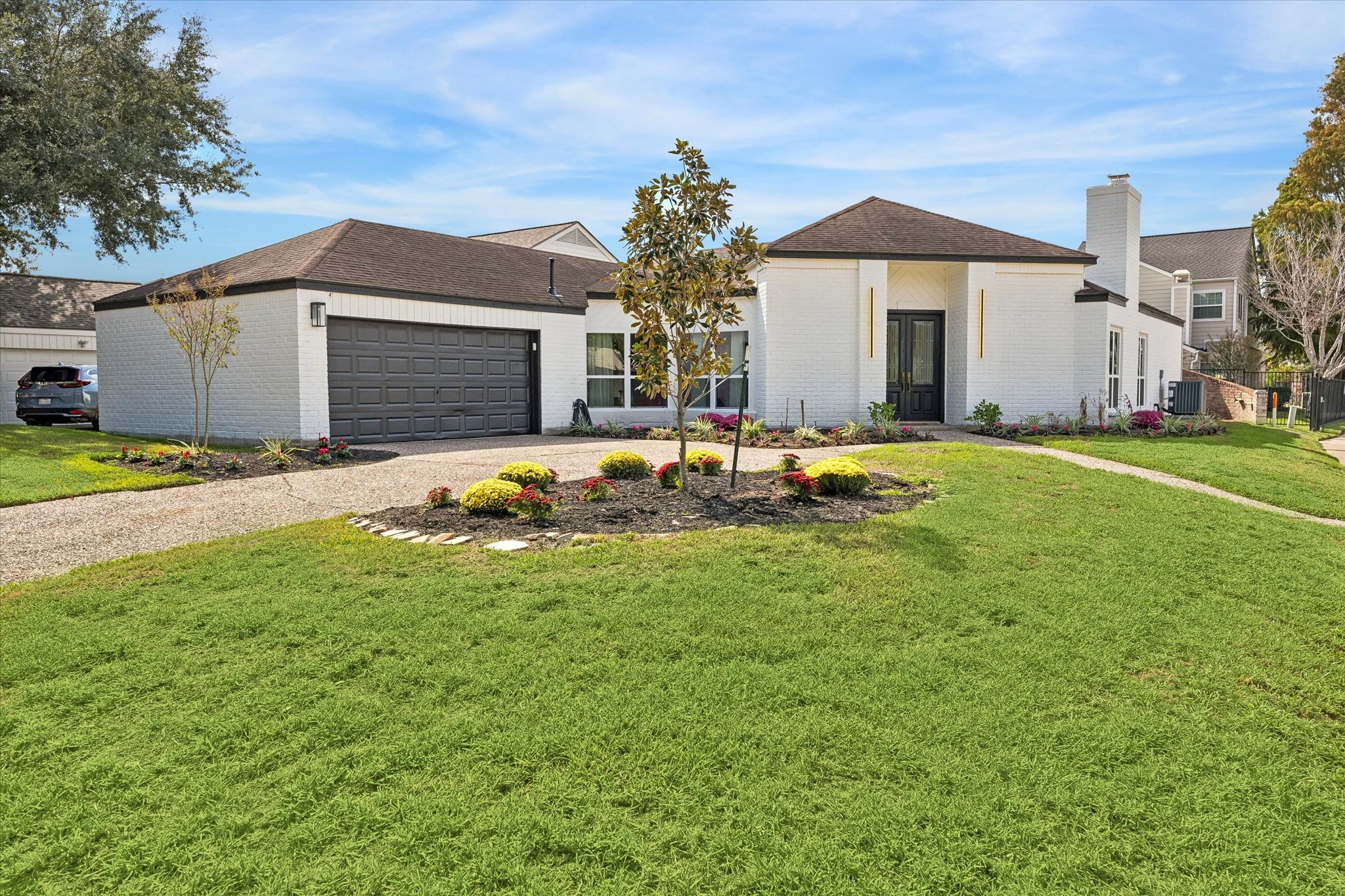 Charming single-story home with a modern touch, featuring a spacious two-car garage, elegant white brick exterior, and a well-maintained front yard with lush landscaping. Charming single-story home with a modern touch, featuring a spacious two-car garage, elegant white brick exterior, and a well-maintained front yard with lush landscaping.