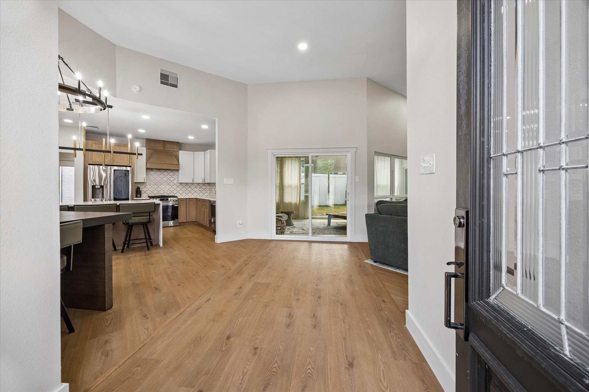 Step into a modern open-concept living area featuring sleek hardwood floors, a stylish kitchen with stainless steel appliances, and a cozy living space enhanced by natural light streaming through large windows. Step into a modern open-concept living area featuring sleek hardwood floors, a stylish kitchen with stainless steel appliances, and a cozy living space enhanced by natural light streaming through large windows.