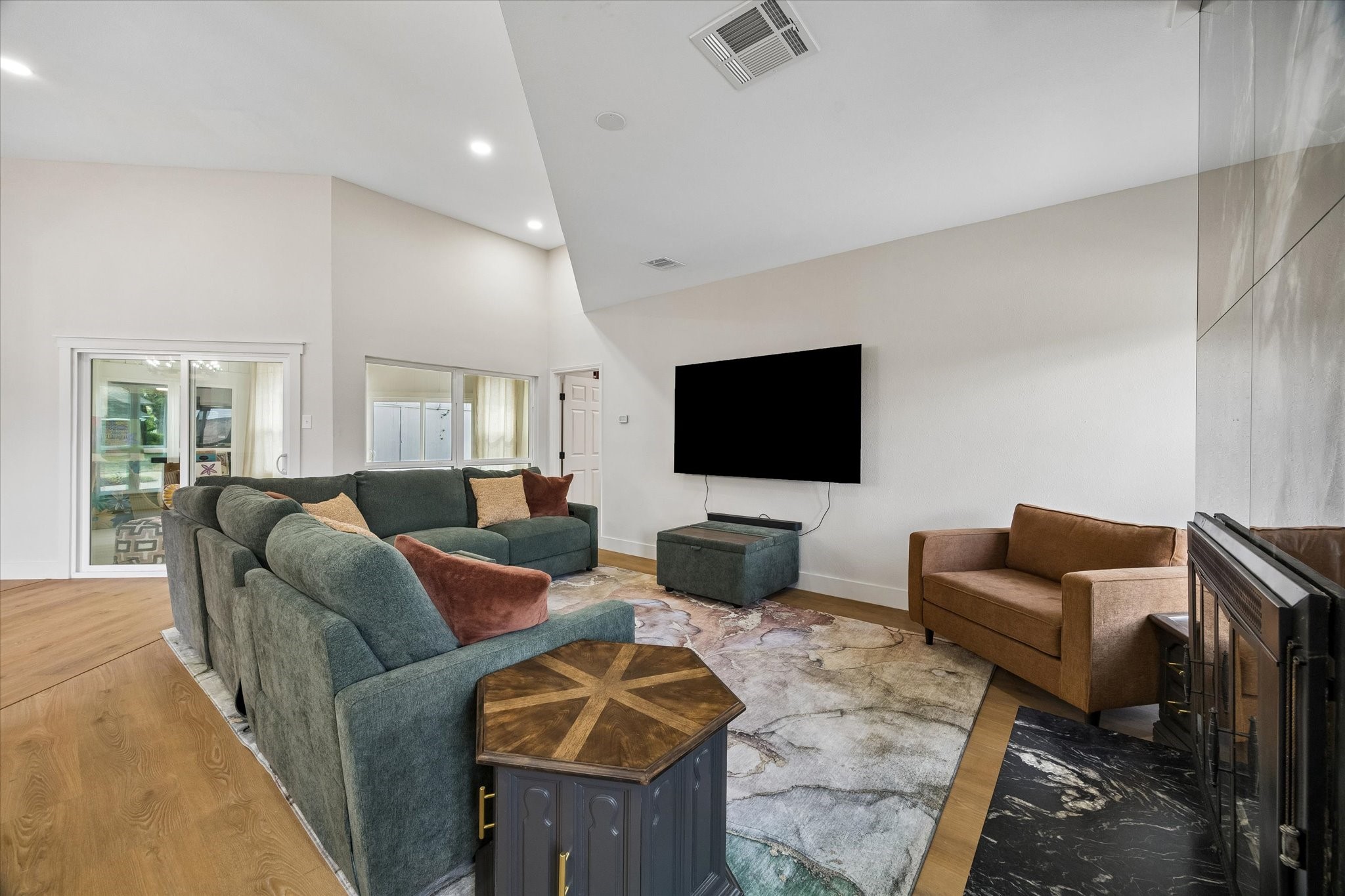 Spacious living room features high ceilings, a modern fireplace and plenty of natural light.