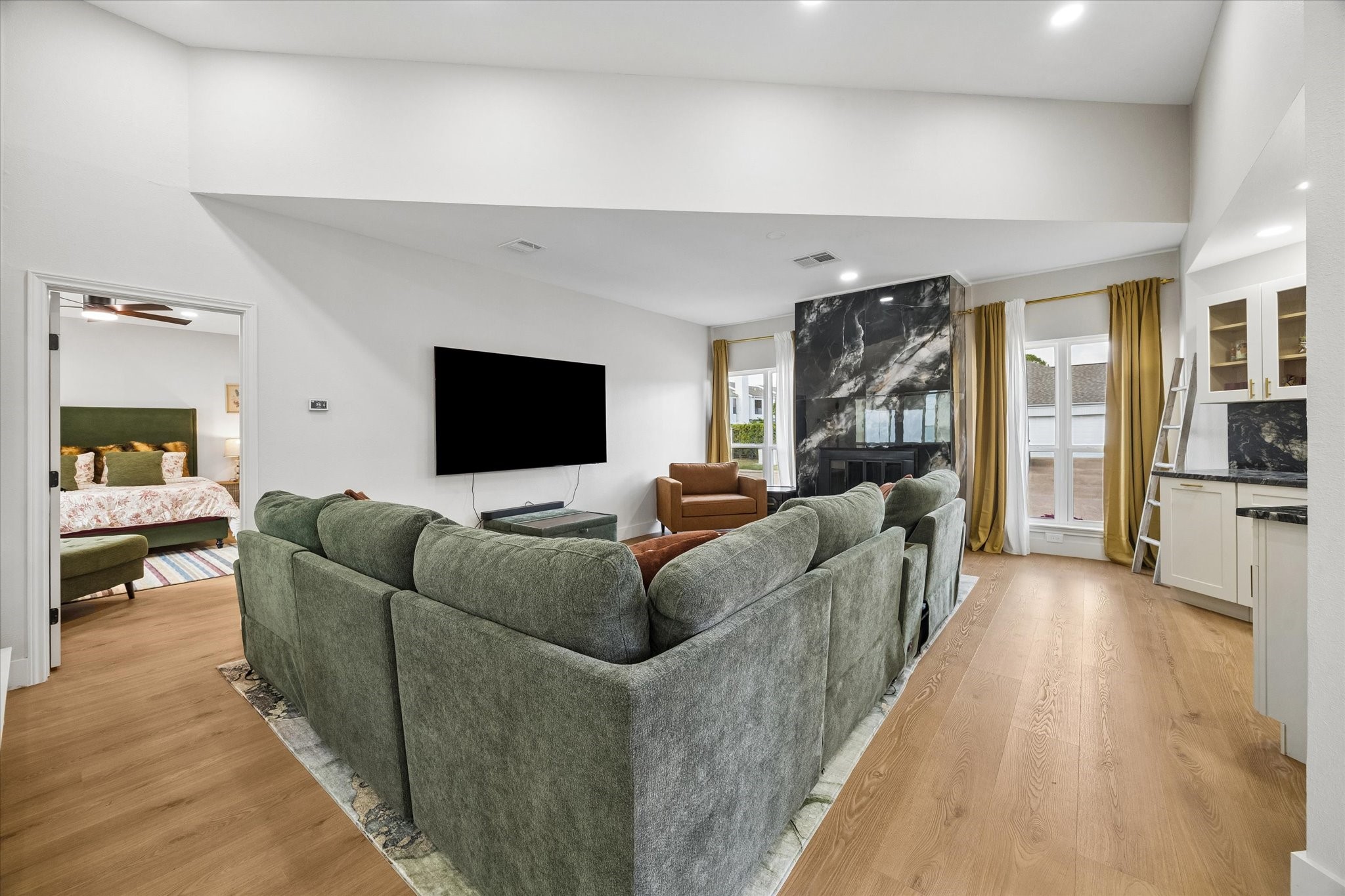 Spacious living area with a modern fireplace, we bar area, floor to ceiling windows and high ceilings make this the perfect gathering space. Spacious living area with a modern fireplace, we bar area, floor to ceiling windows and high ceilings make this the perfect gathering space.