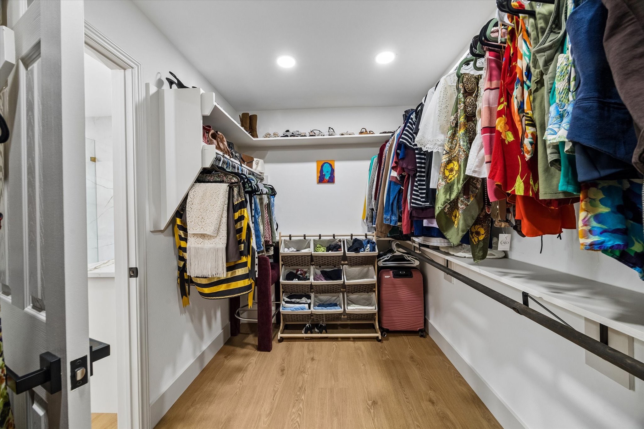 Spacious walk-in closet with ample shelving and hanging space, featuring modern lighting and a convenient layout for easy organization.