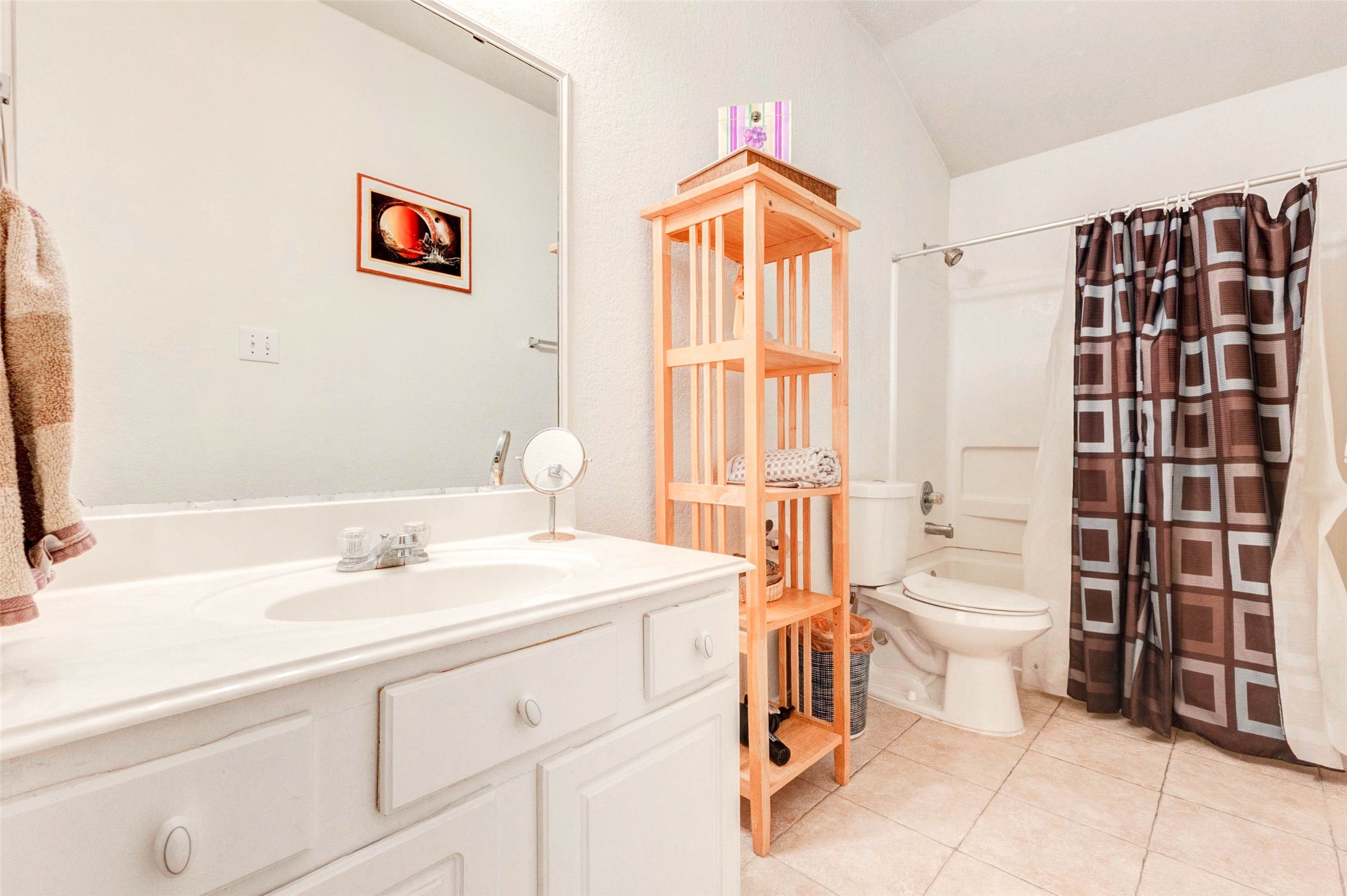 Well-maintained bathroom featuring a single-sink vanity with generous counter space and storage below. A full tub and shower combination offers convenience, while the neutral color palette creates a clean and functional environment. Thoughtful layout and natural light make this bathroom both practical and comfortable for daily use.