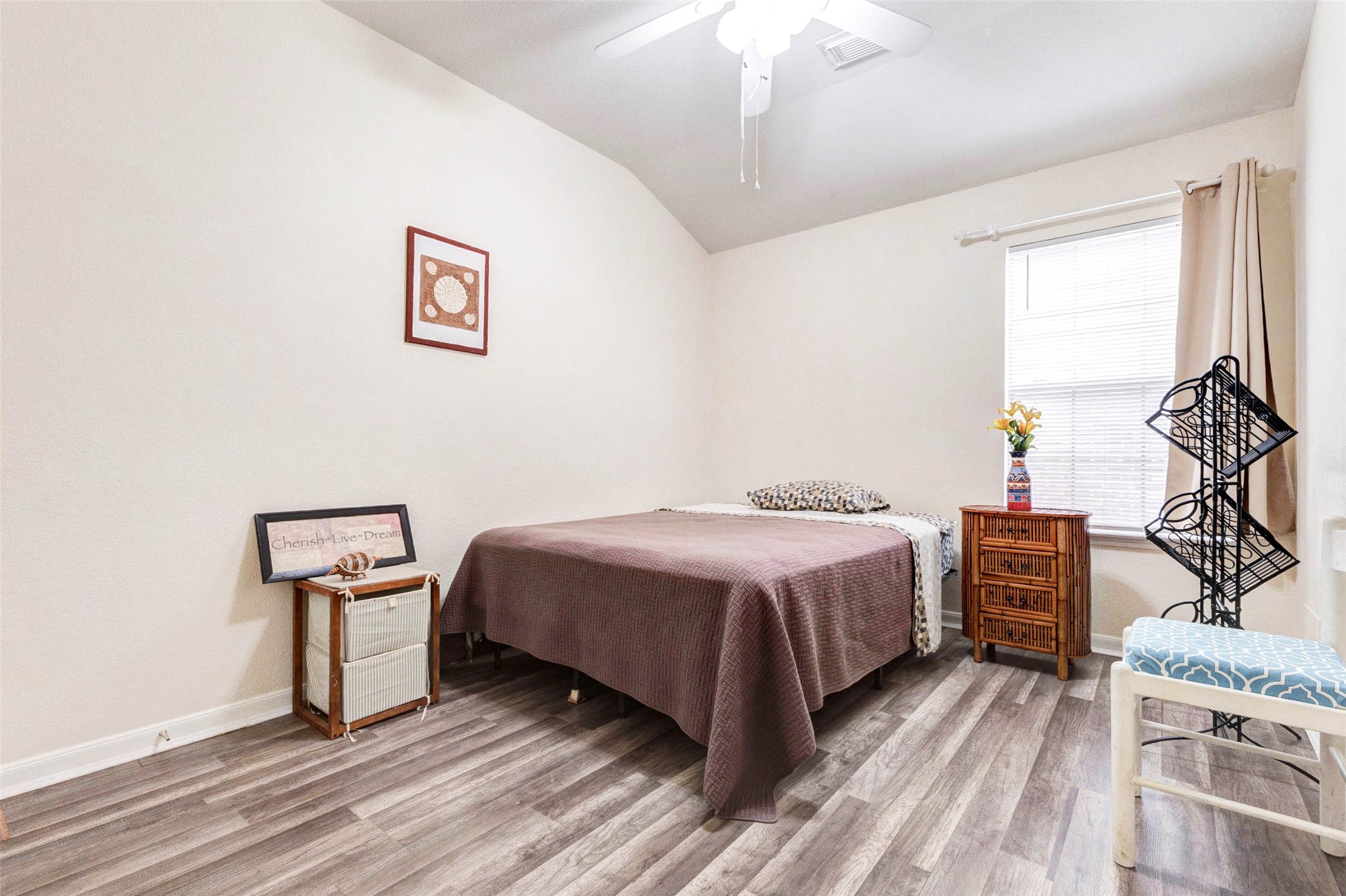 Comfortable secondary bedroom with updated flooring and a bright, inviting atmosphere. A large window allows natural light to fill the space, while neutral tones make it easy to personalize. Ideal for guests, family members, or a home office, this room offers both flexibility and comfort.