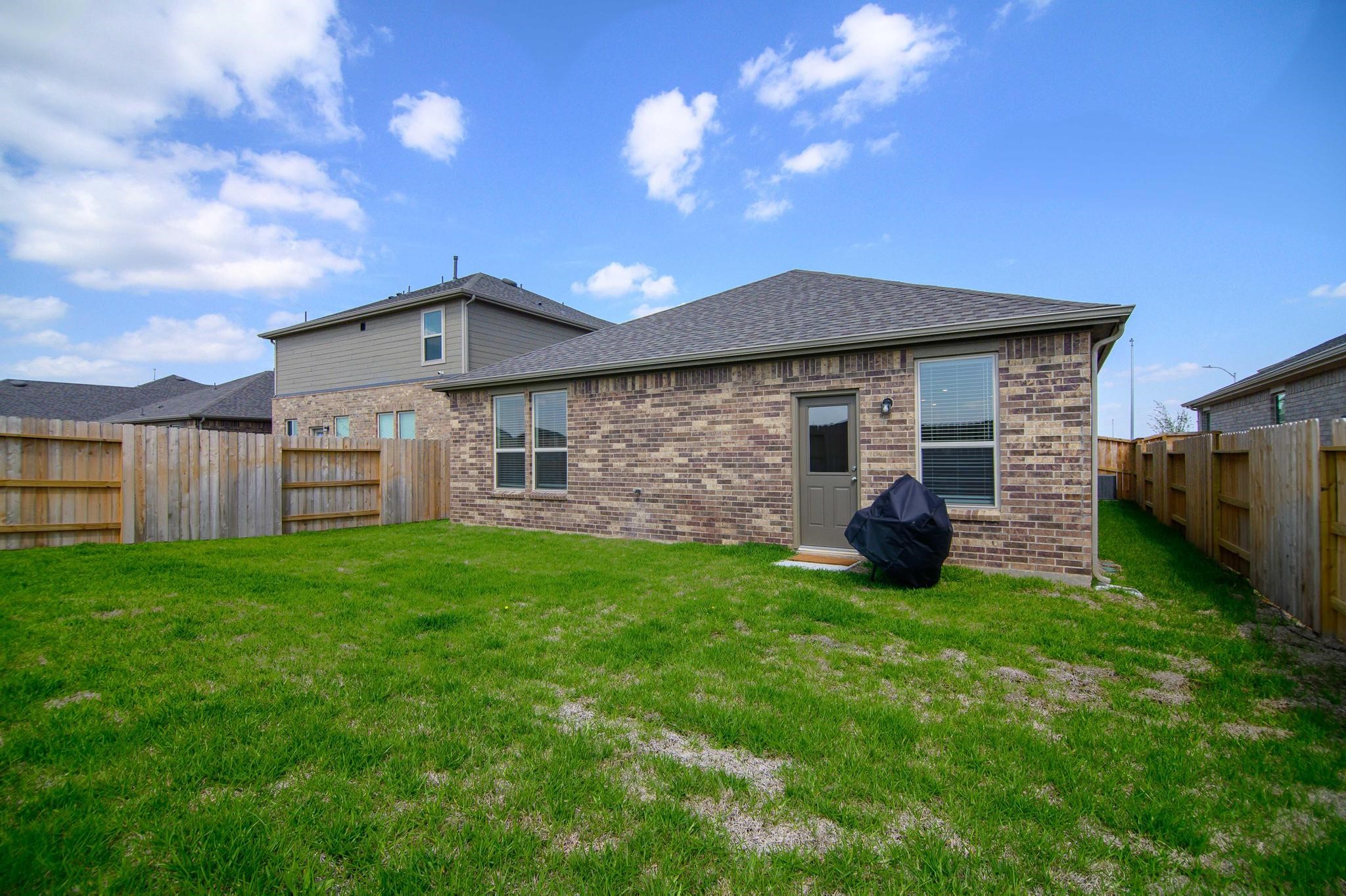 Charming brick home with a spacious fenced backyard, perfect for outdoor activities and relaxation.