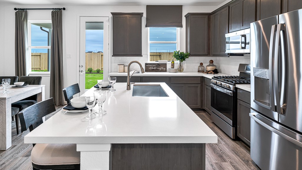 Kitchen has open views to the beautiful backyard. Designer colors and finishes lend to the upscale, sophisticated ambiance.