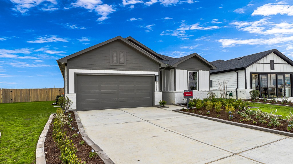 Rock-lined landscaped beds line the driveway.