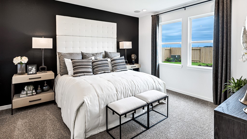 Primary suite has a gorgeous statement wall in black that looks fantastic with the designer white walls. Custom drapery in charcoal color ties room together perfectly.