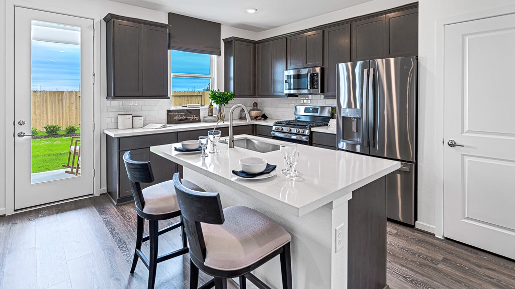 Central island has room for seating with crisp white quartz counters.