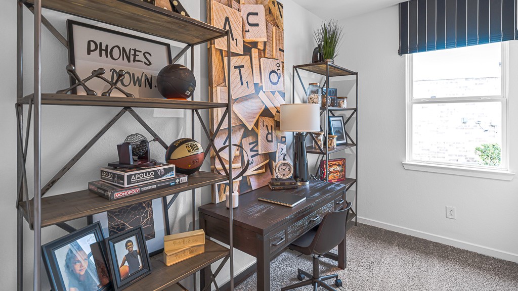Home office has room for a desk and storage shelves. Great window with modern valance adds style.