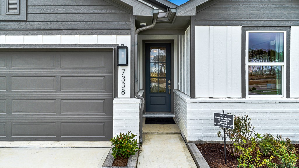 Modern wall lantern highlights the floating address numbers and the gorgeous custom front door for a welcoming entrance.