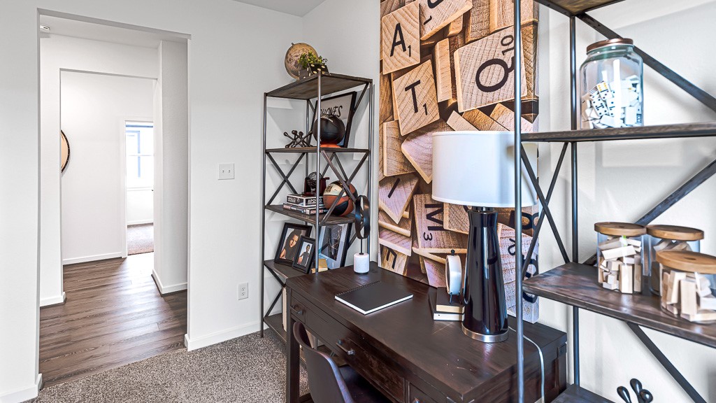 Home office has designer white walls and premium warm gray carpeting.