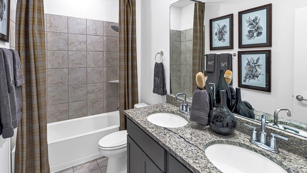 Bathroom 2 has a modern double sink vanity with striking black cabinetry, crisp white undermount sinks, tied together with gorgeous granite counters and silver fixtures. Tub/Shower Combo.