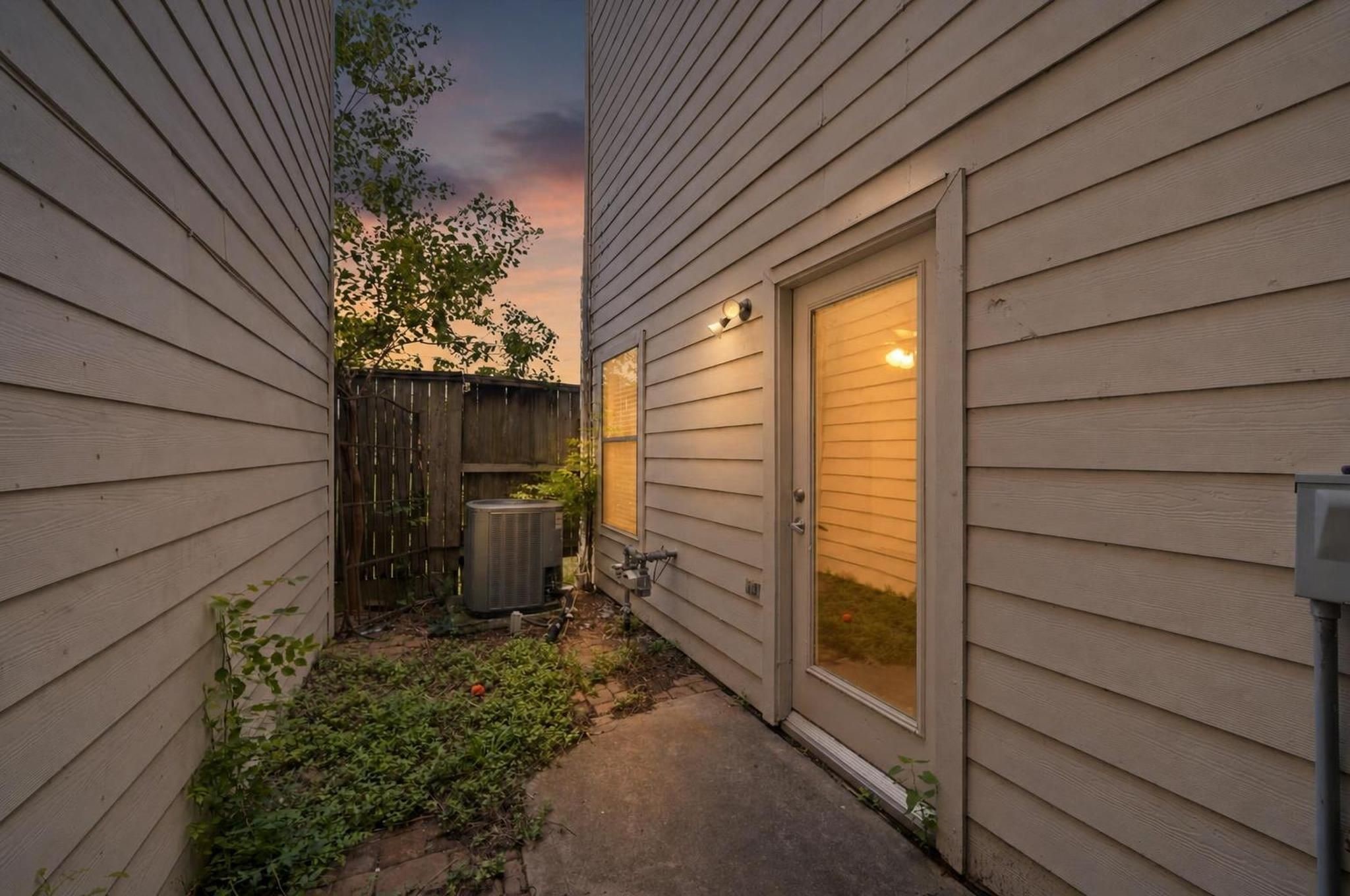 The back patio offers a private outdoor escape tucked behind the home. It is an easy place for plants, a small seating area, or a quiet moment outside.