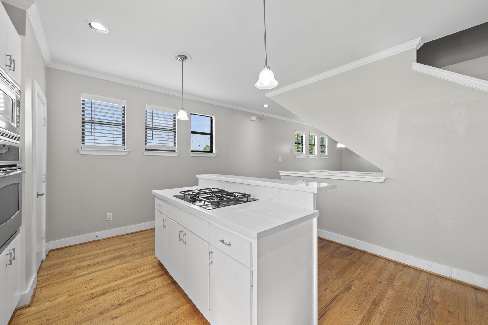 The island with cooktop creates a strong centerpiece for the kitchen. It keeps cooking, conversation, and entertaining connected in one central space.