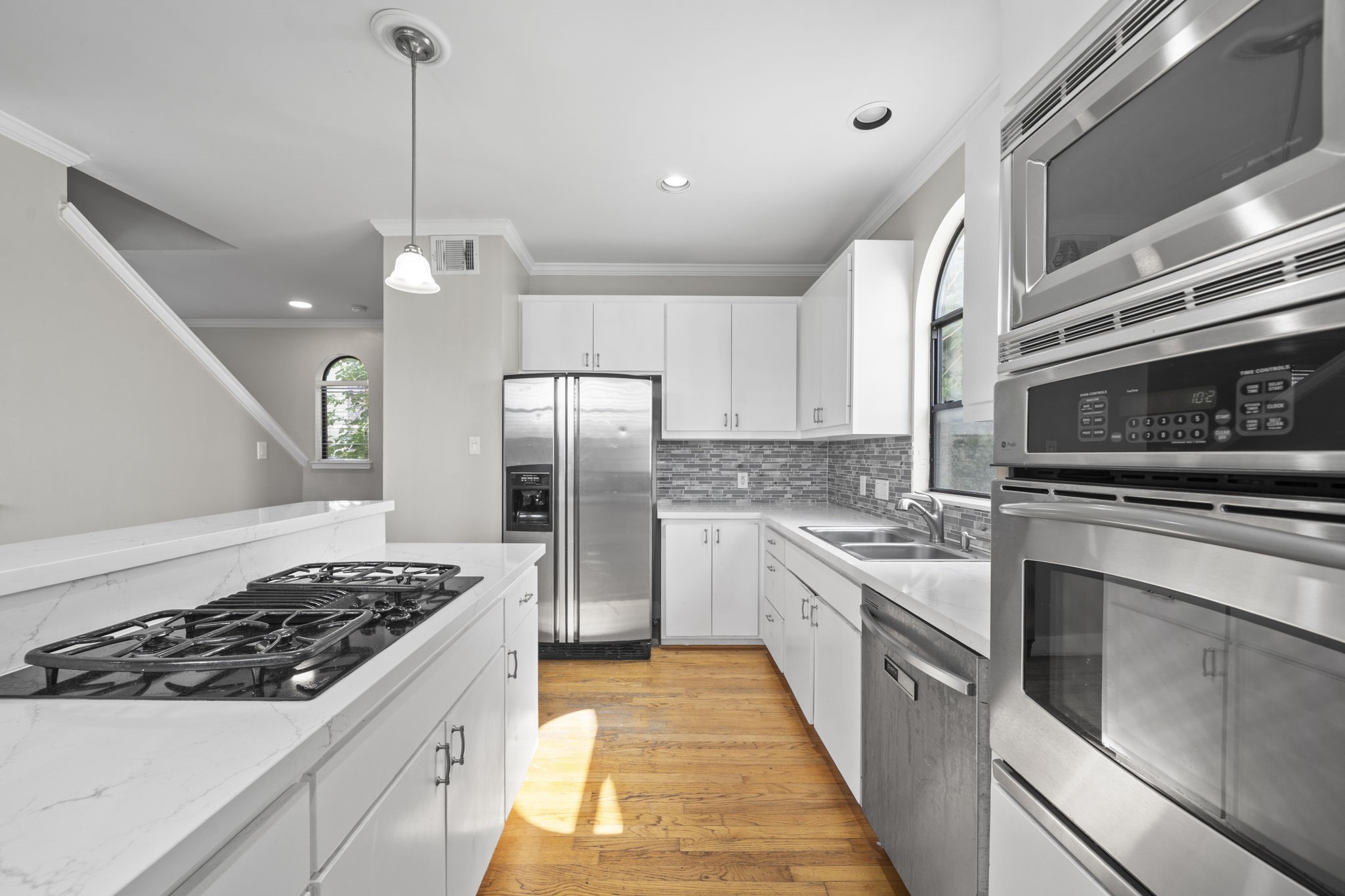 The quartz countertops and clean finishes give the kitchen a sharp, updated presence. Every detail feels simple, functional, and ready for everyday living.
