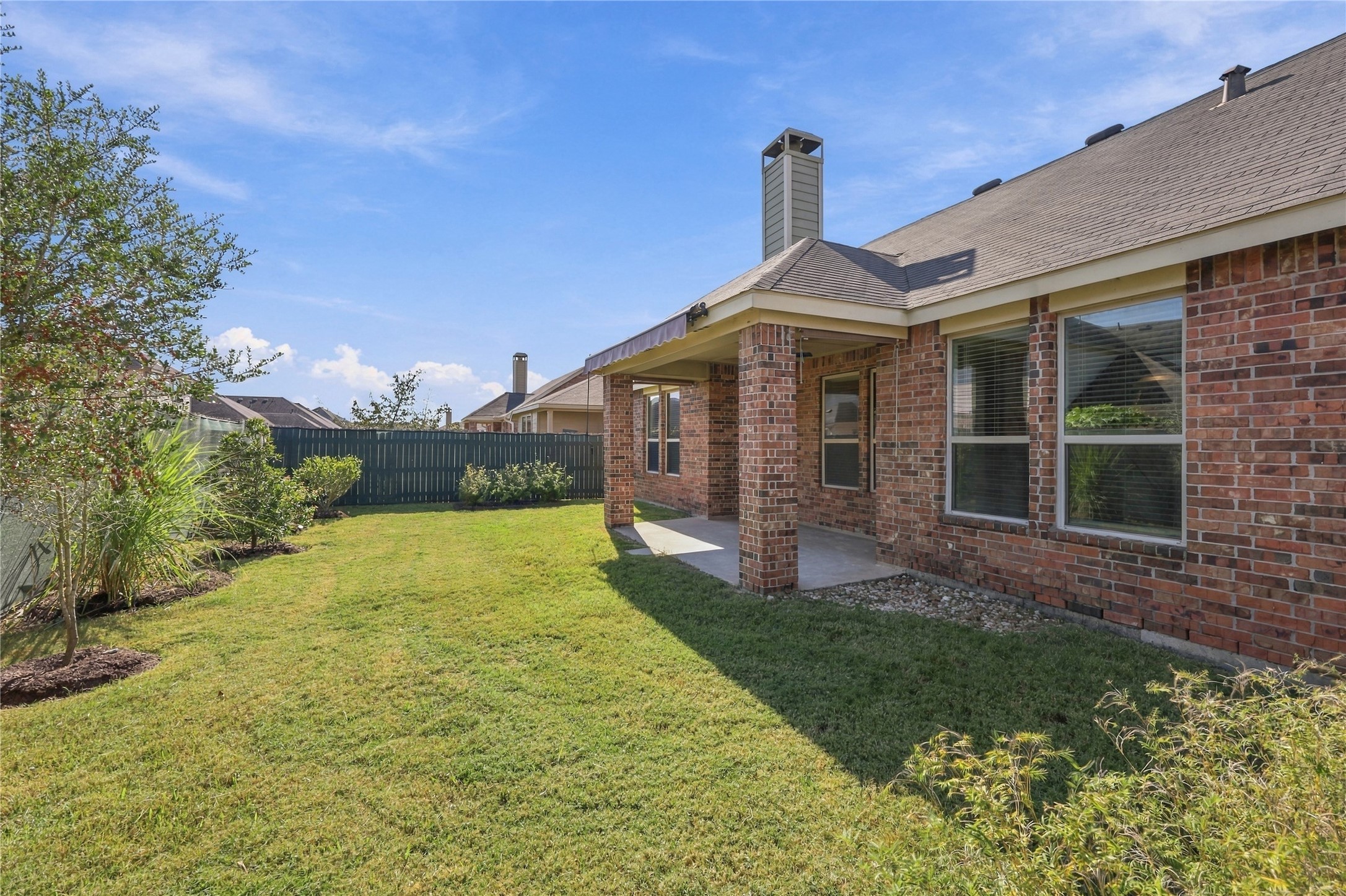 A privacy fence, and a spacious covered patio with an extendable shade awning, perfect for outdoor relaxation and entertaining!
