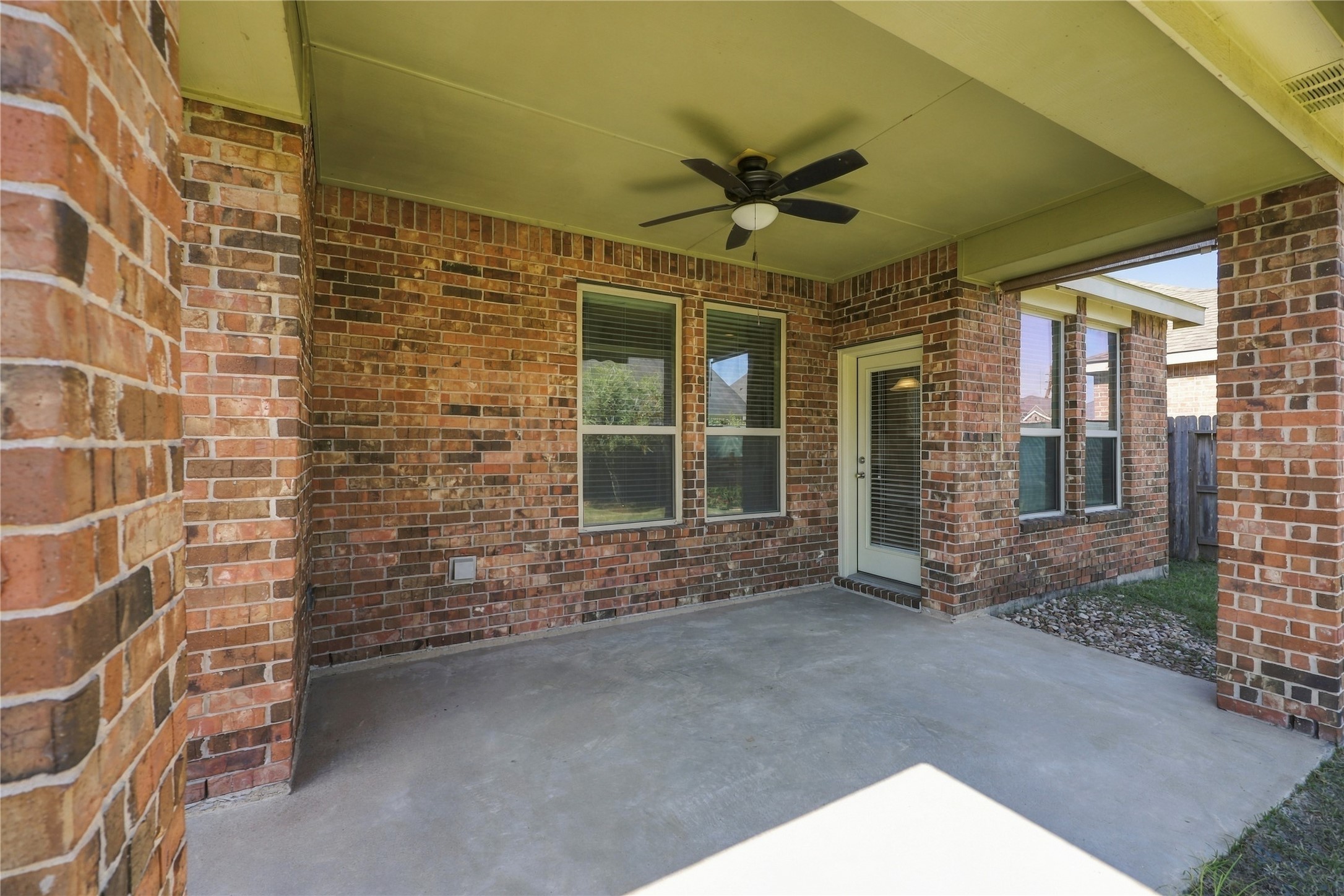 This spacious covered back patio features a ceiling fan for added comfort and plenty of room to relax, entertain, and enjoy the outdoors year round!