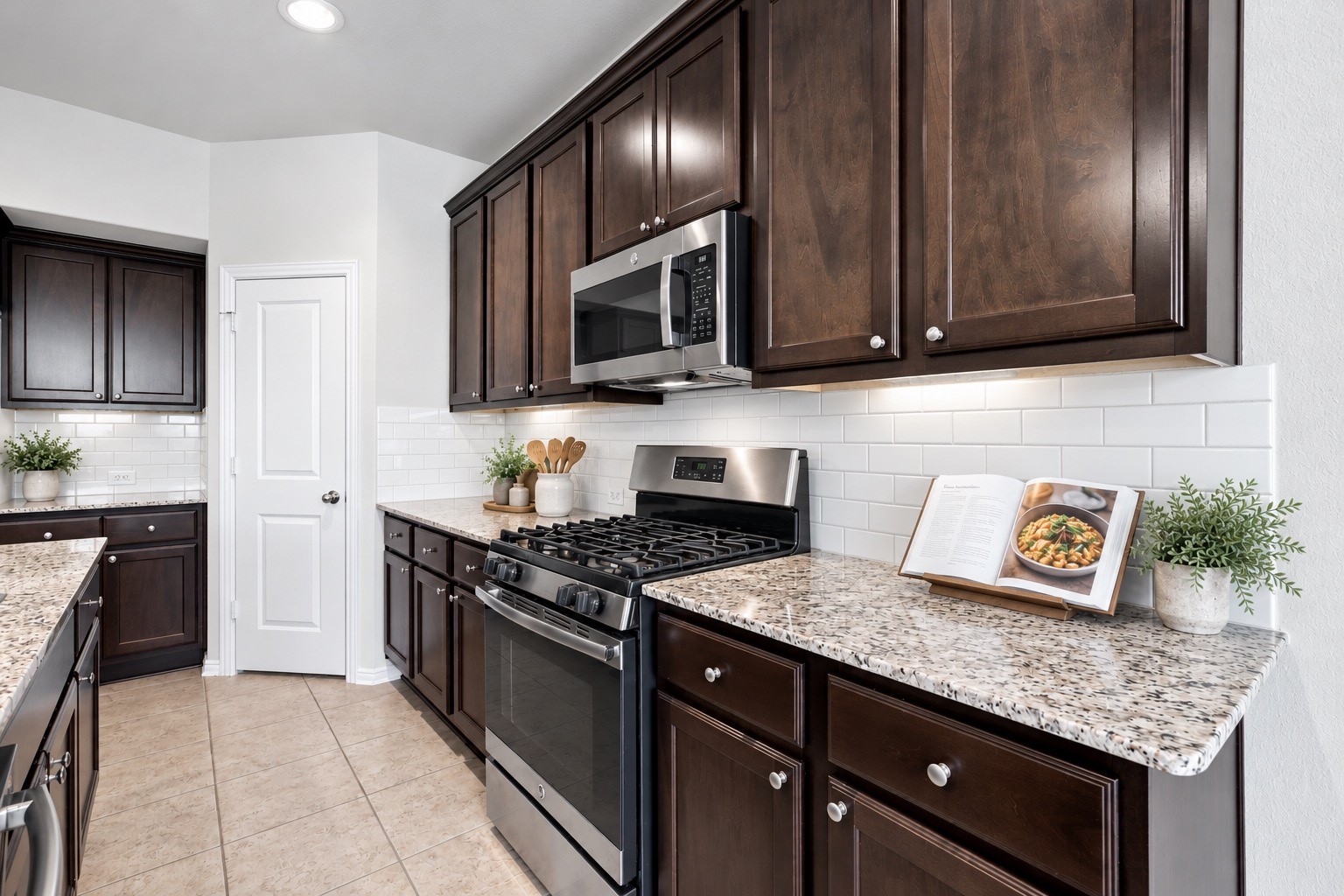 This inviting kitchen features rich dark cabinetry, beautiful granite countertops, and a classic tile backsplash.
*Virtually staged.*