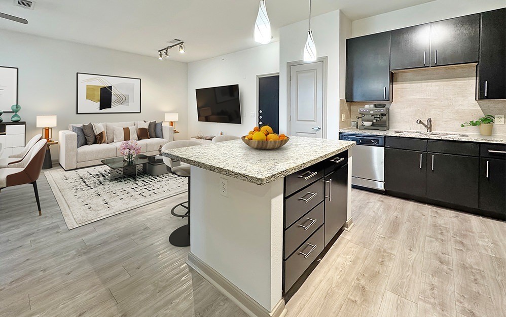 Sleek designer kitchen with granite countertops, stainless steel appliances, rich cabinetry and an oversized island that opens seamlessly to the living area.