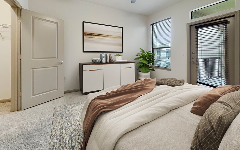 Serene primary bedroom with abundant natural light, generous space and direct access to a private balcony for an elevated indoor-outdoor living experience.