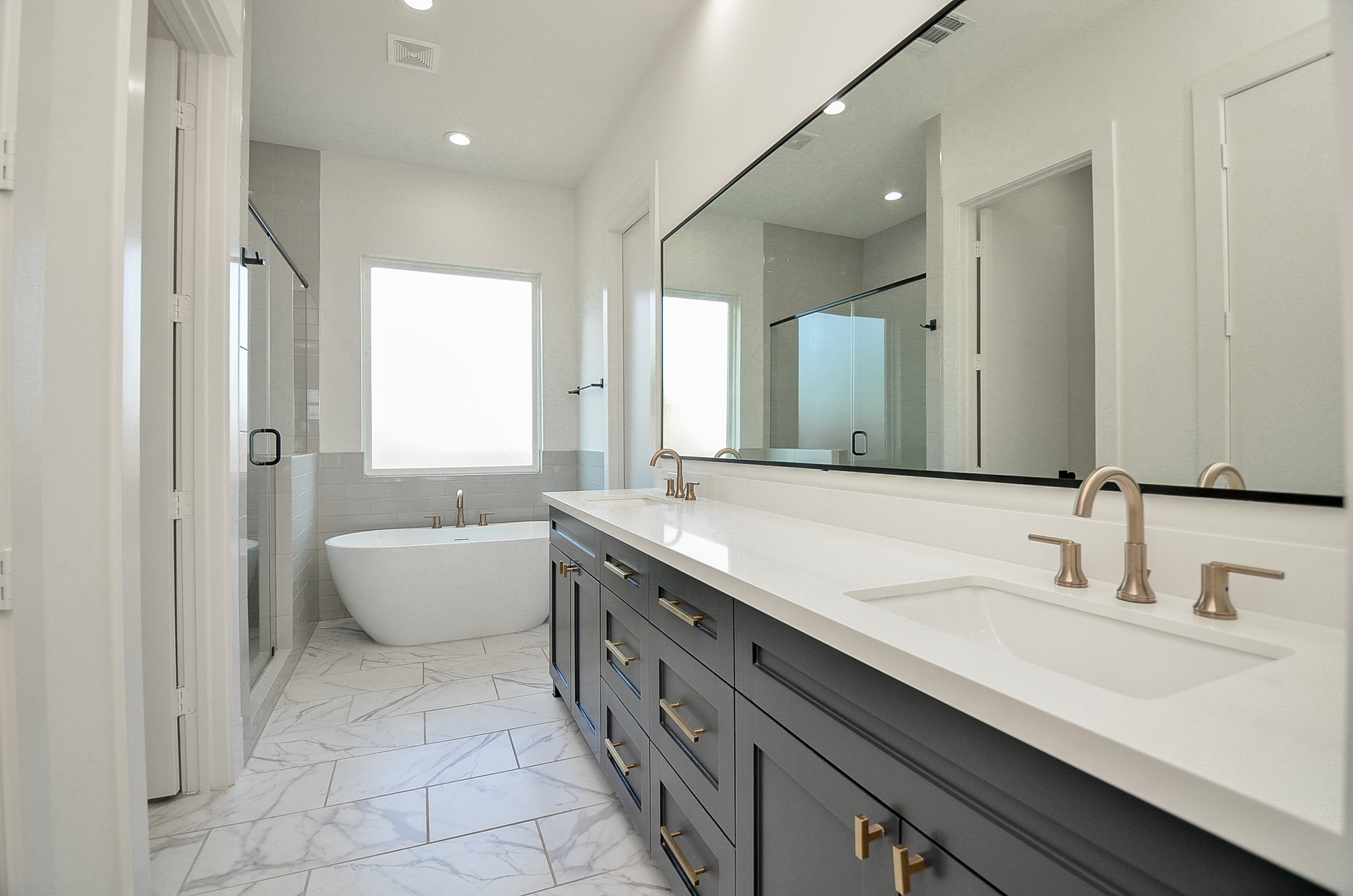 The primary bath includes dual sinks and an extended vanity provide counter space and storage.