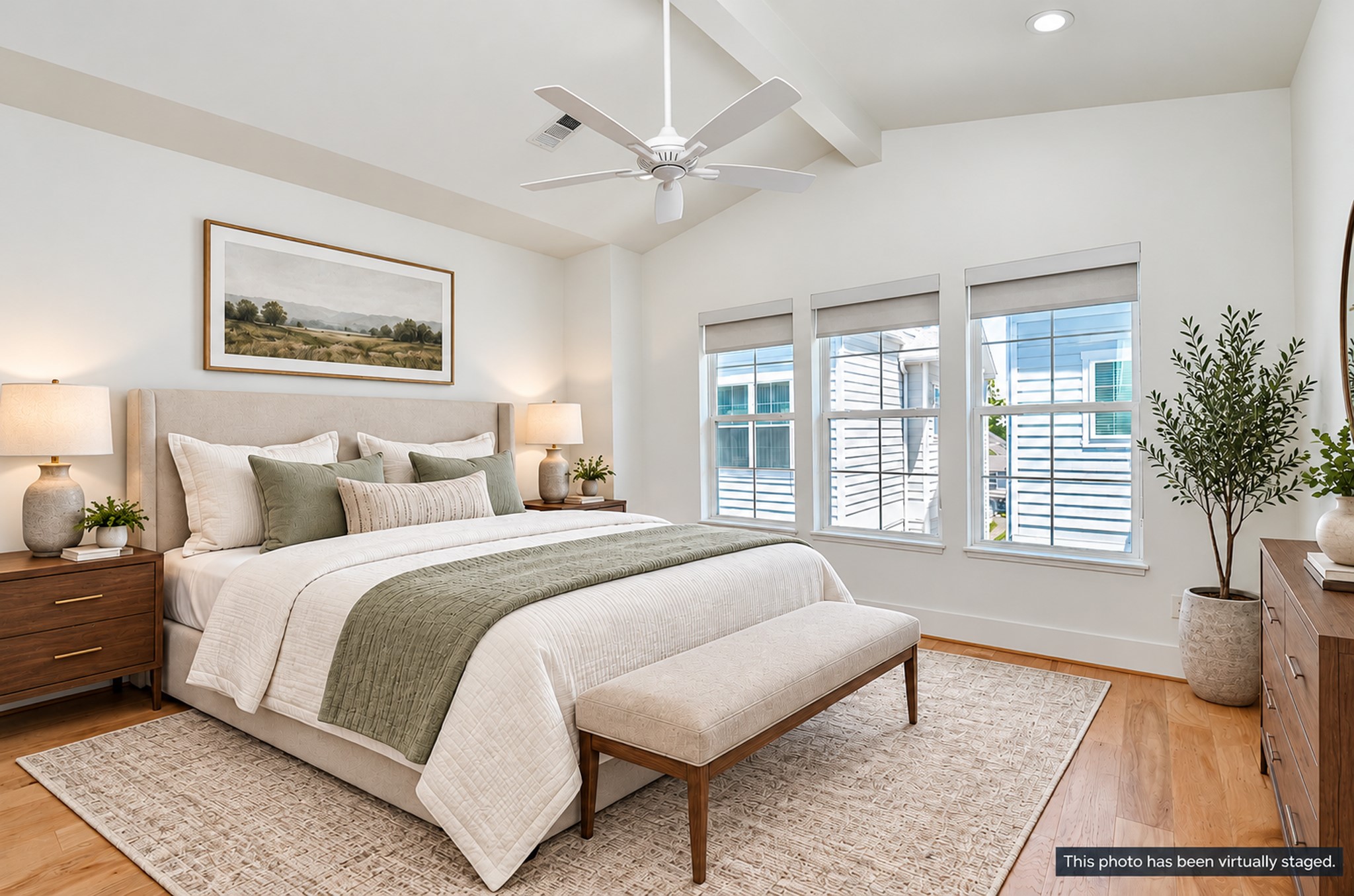 Third-floor primary suite with vaulted ceilings and wood flooring.