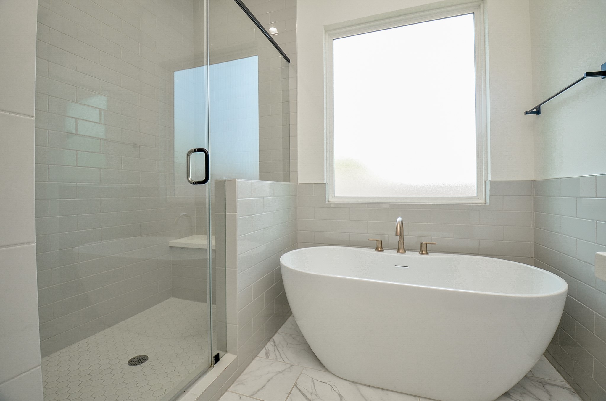 The primary bath includes a freestanding soaking tub and separate glass-enclosed shower.