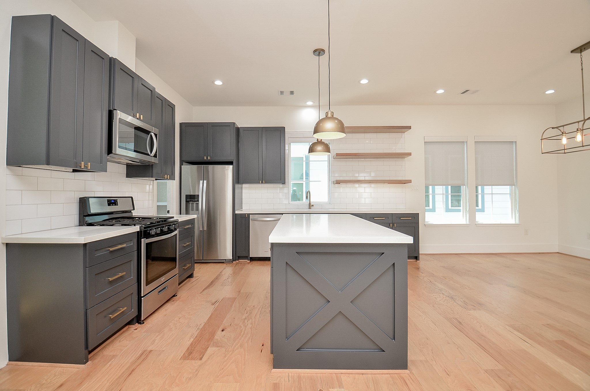 Quartz counters, gas cooking, and a generous island anchor the kitchen.