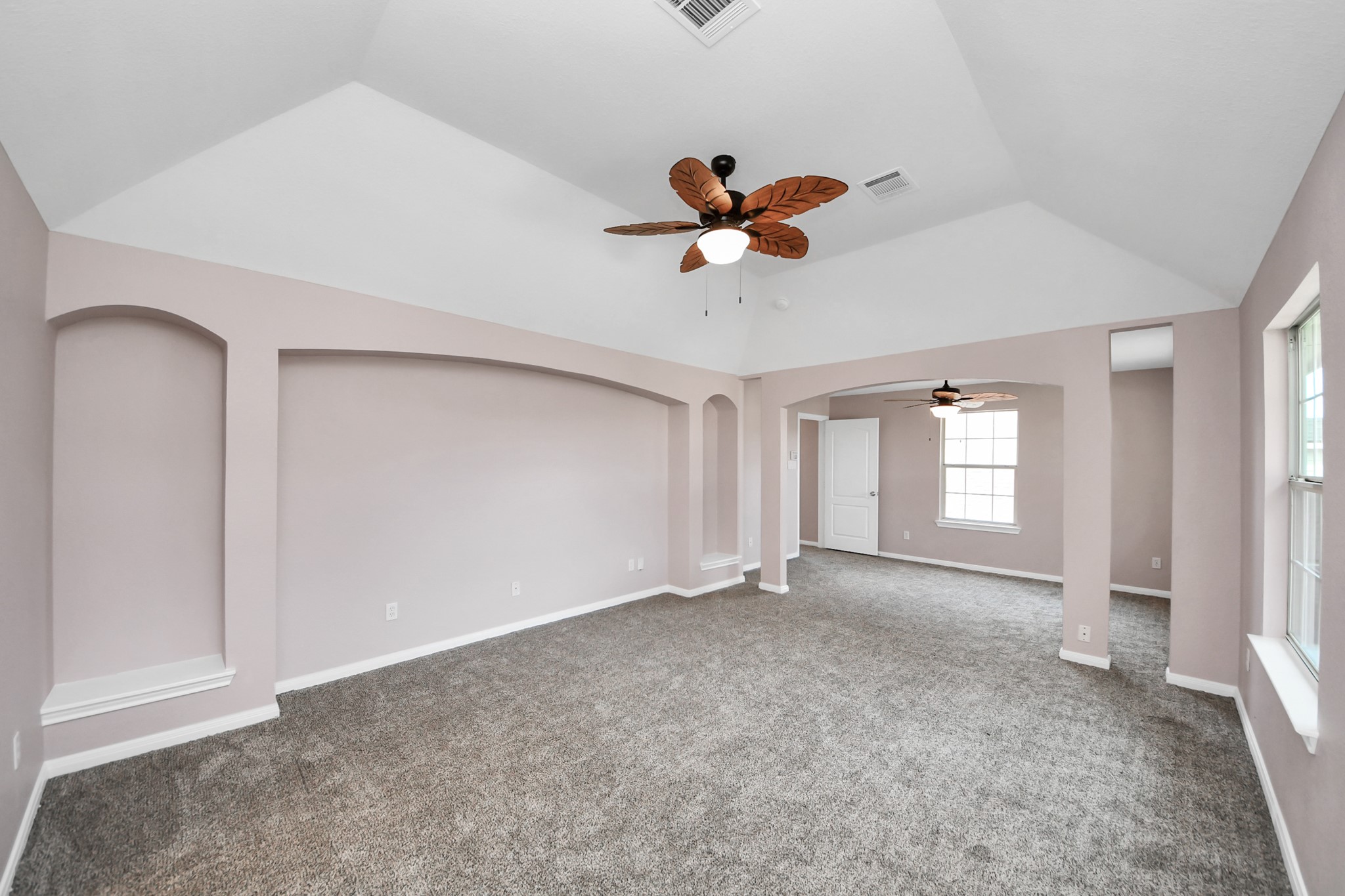 Experience the spacious elegance of this primary suite, featuring vaulted ceilings, soft carpeting, and abundant natural light, creating a perfect retreat.