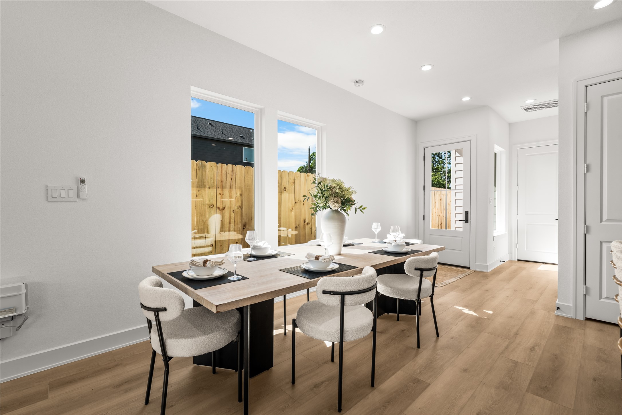 This bright corner of the dining area gets plenty of afternoon sunlight while still keeping your privacy. The clean white walls are ready for your own artwork, and the light continues through the space to keep everything matching and modern.