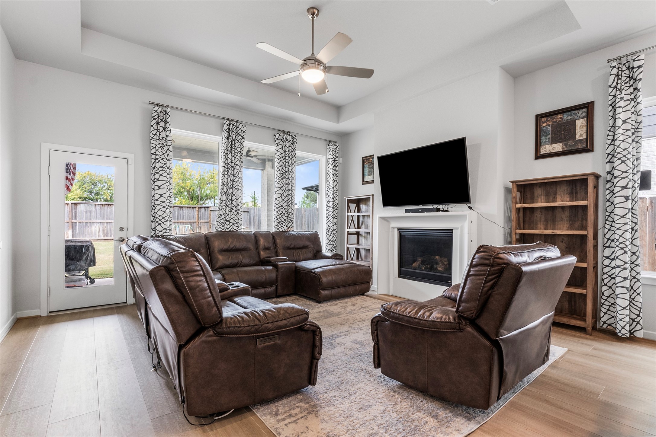 The adjoining living space offers ample seating, natural light, and a cozy fireplace, perfect for entertaining.