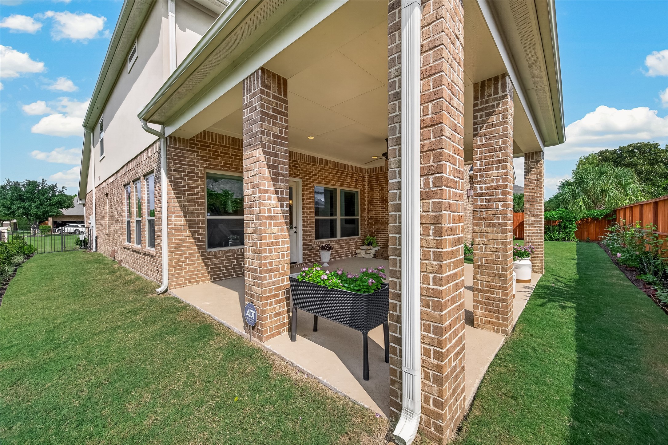 Covered Back Patio with lush landscaping, gas hookup ready for outdoor kitchen