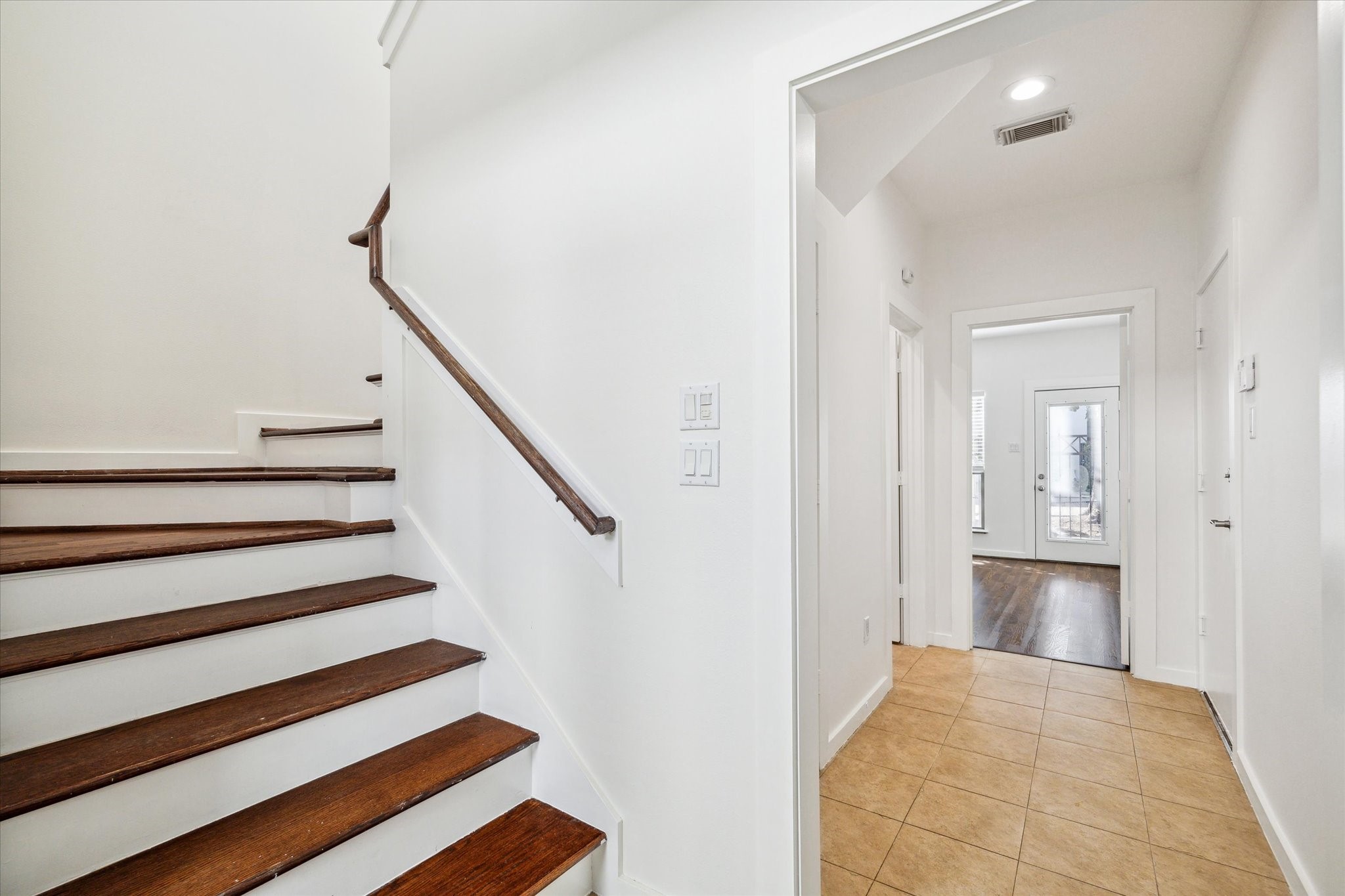 Entry with crisp white interior, just ahead, you'll find the first floor bedroom and bathroom, along with access to the fenced in patio/yard.