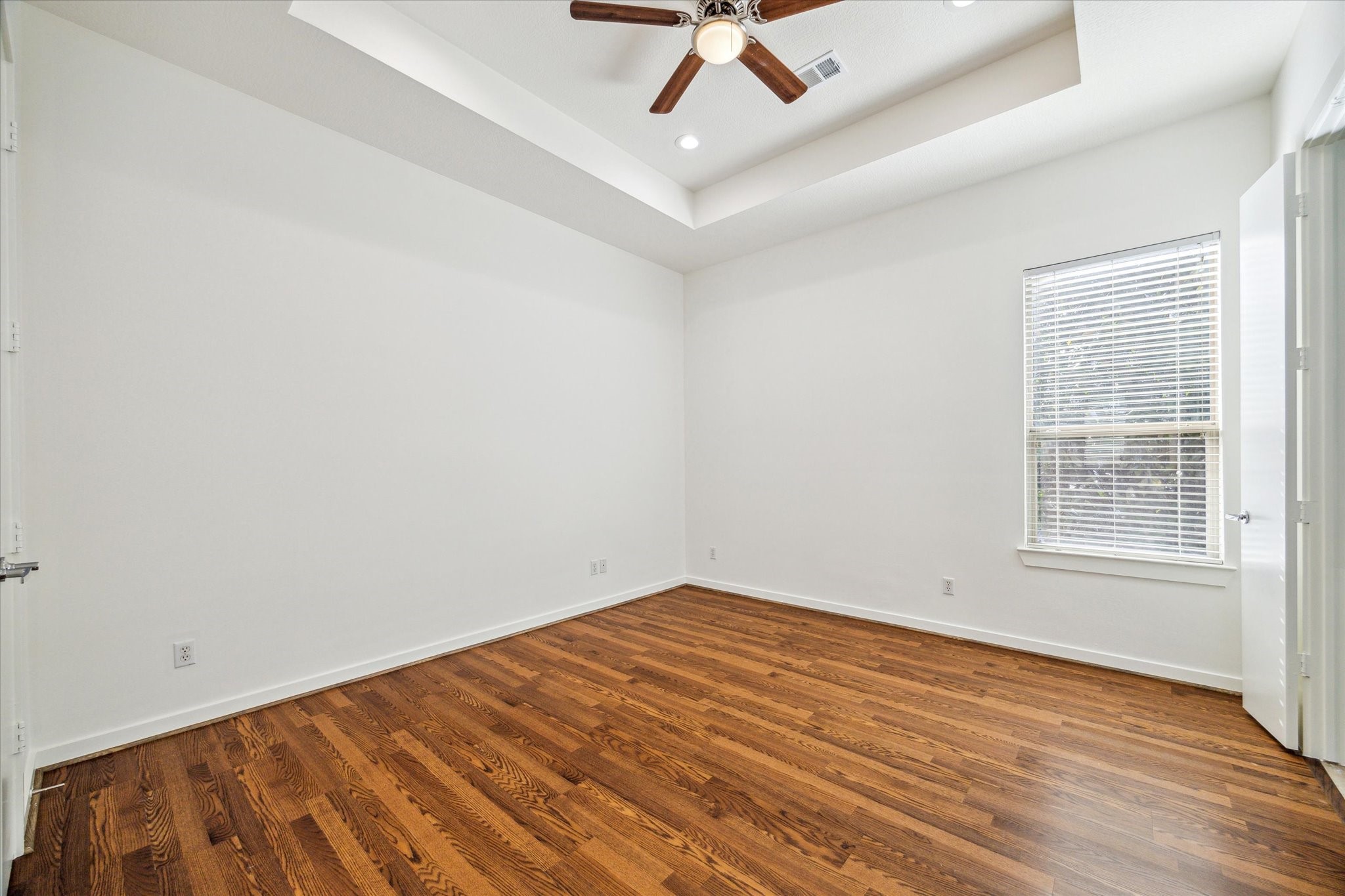 Primary bedroom with recently installed laminate floors. This room has two closets-one in the bedroom and the second in the primary bathroom.