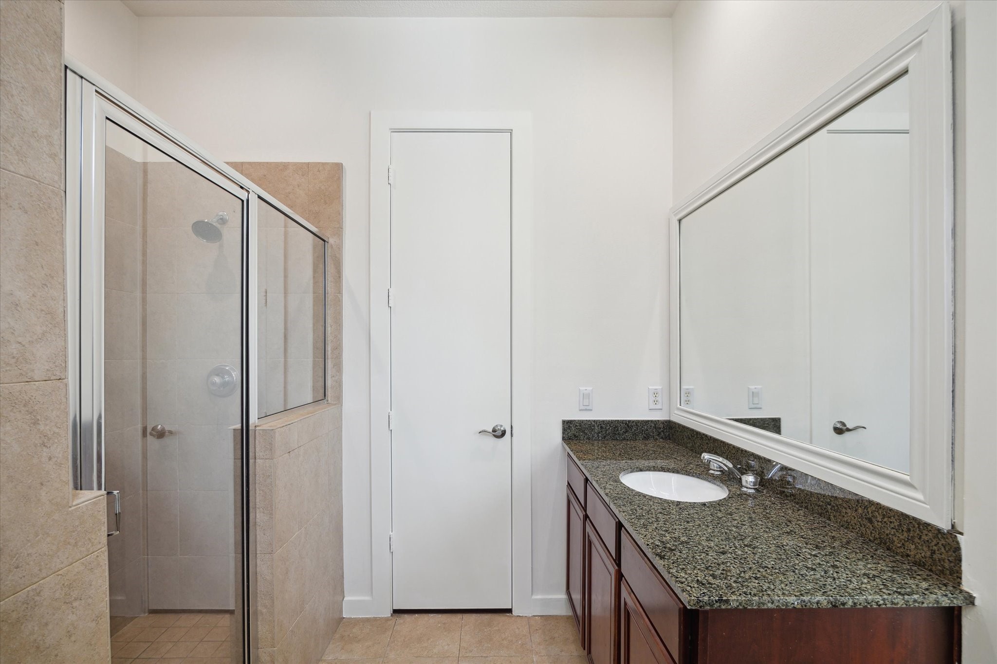 Walk in shower with 2 updated showerheads and new shower tile floor, plus the door ahead leads to the second closet.