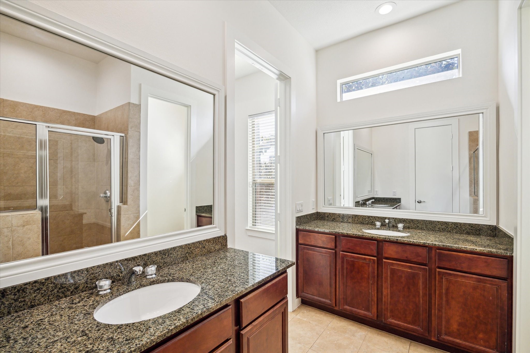 Separate vanities with granite counters and ample storage. There is also a separate water closet.
