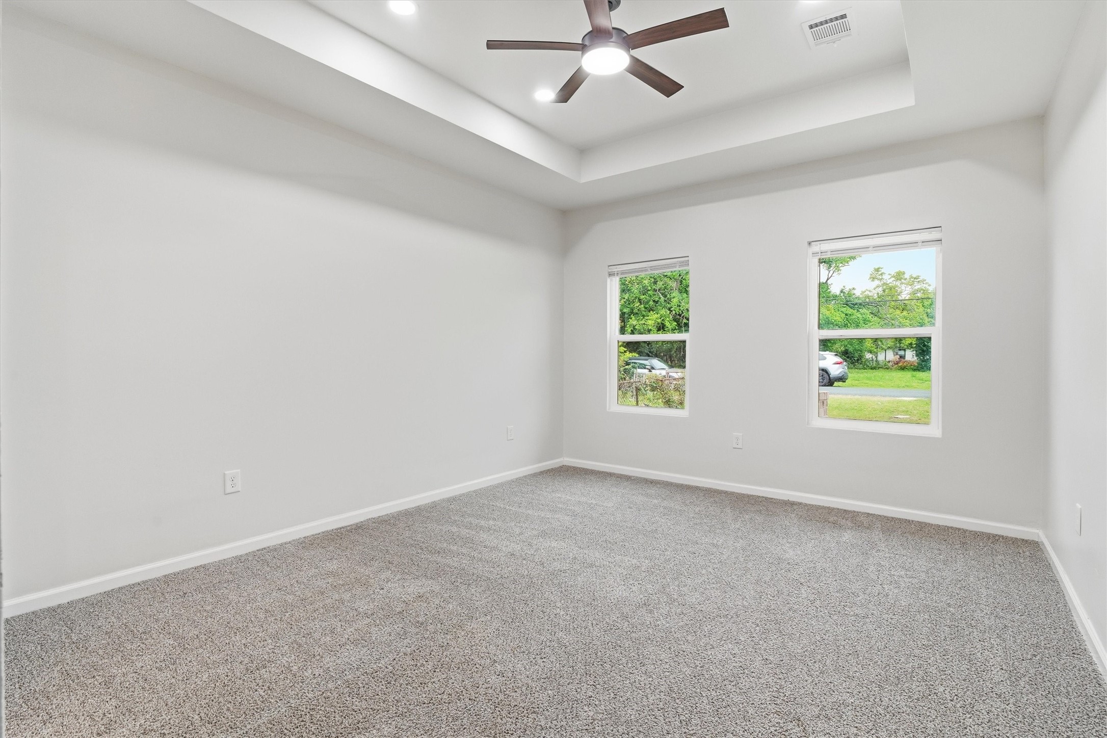 Primary bedroom with brand new carpet, paint and updated ceiling fan