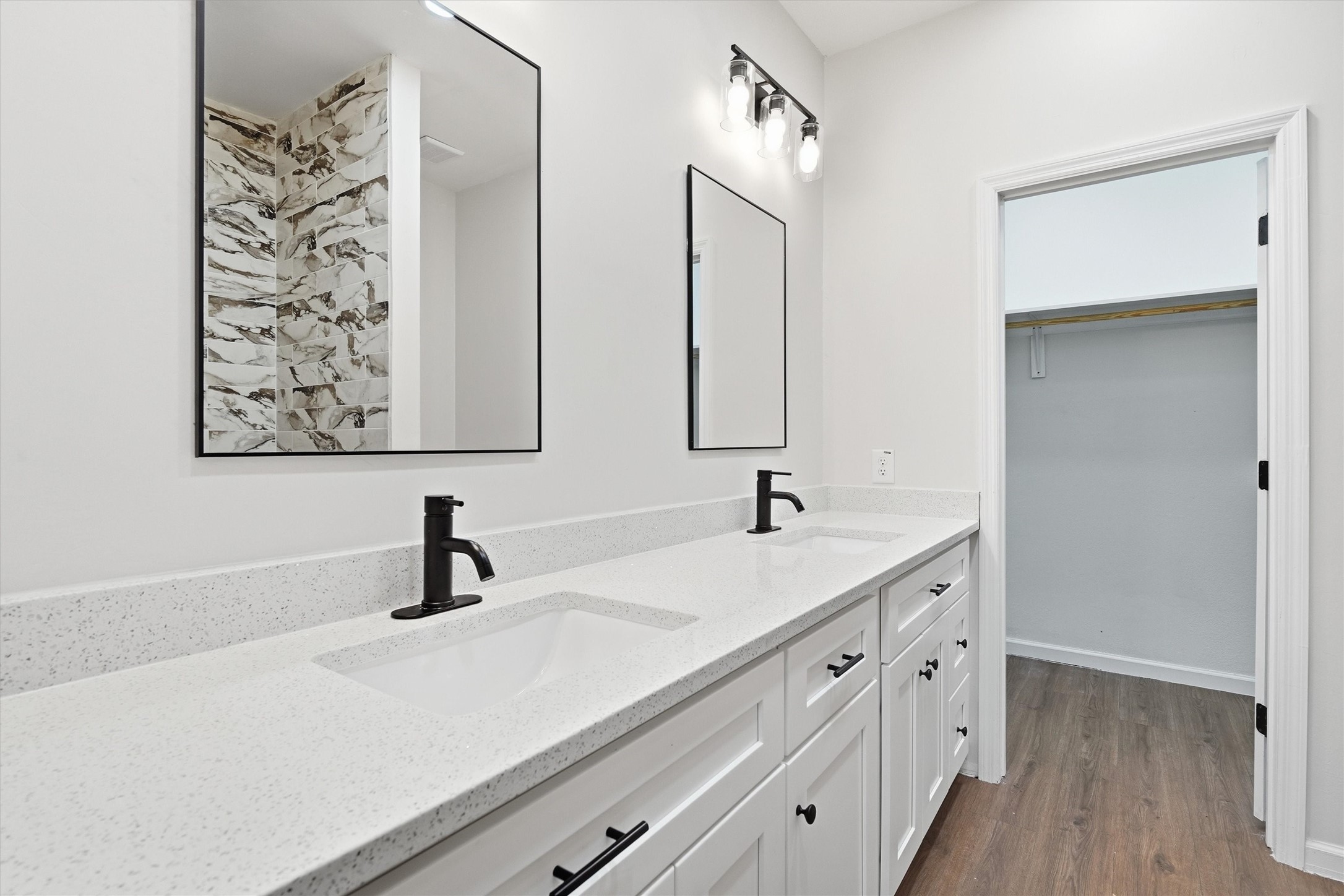 En suite featuring double sinks, modern mirrors and lots of counter space
