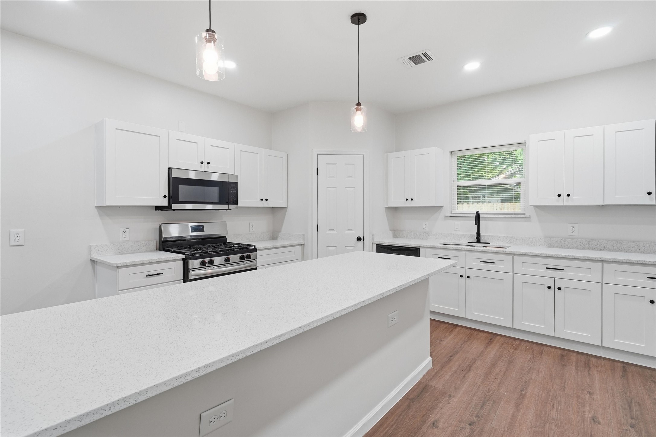Light and bright kitchen with extra large island, stainless steel appliances