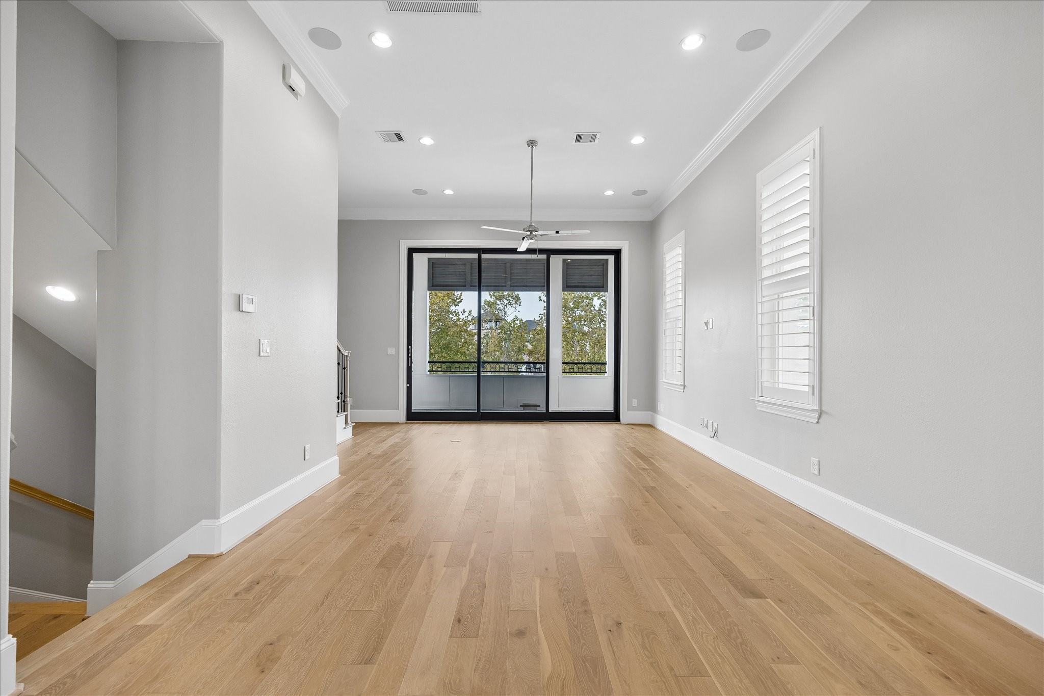 Spacious living area with elegant hardwood floors, abundant natural light, and a modern ceiling fan, leading to a large window with a scenic Lake views.  This is a gourgeous picture of what you view everyday.